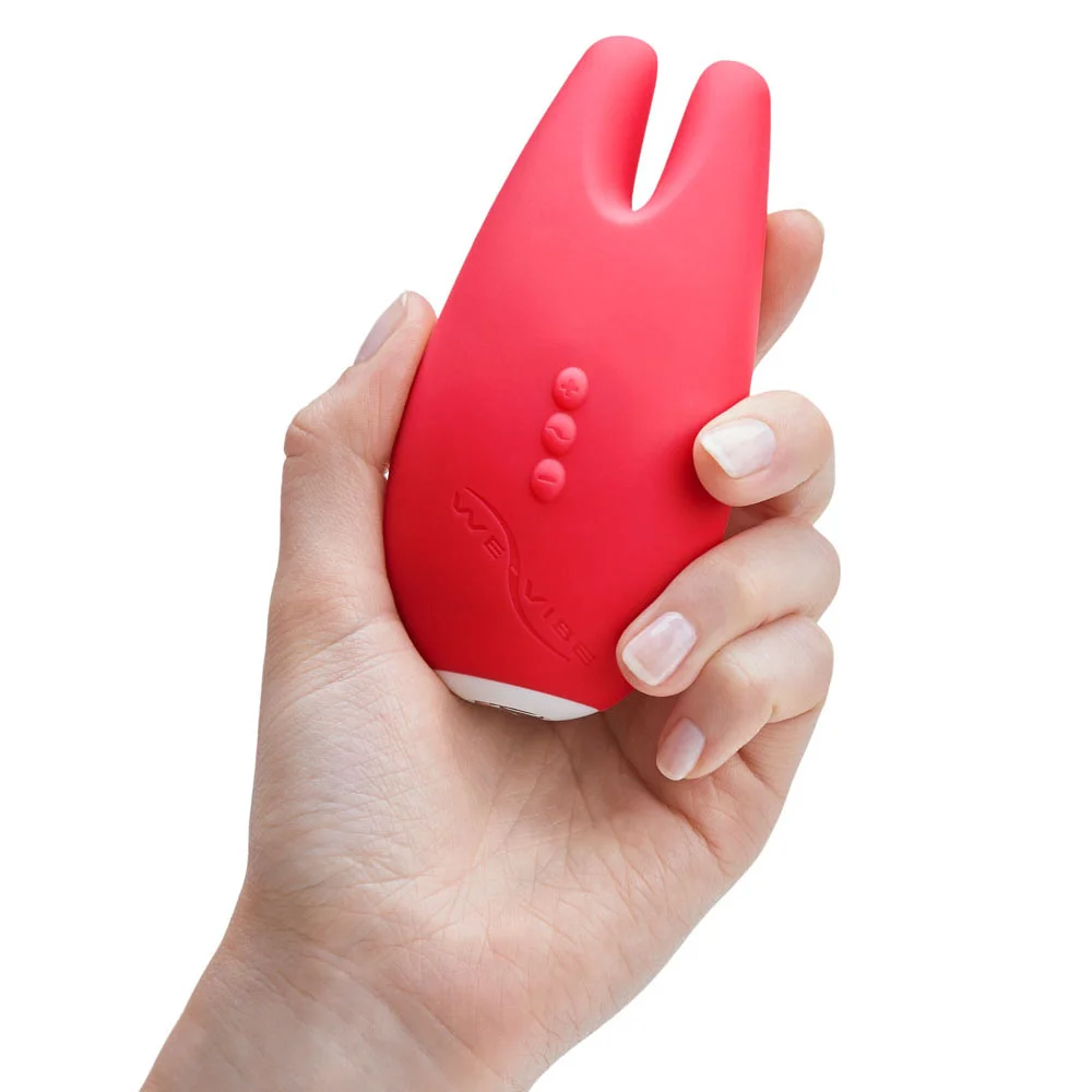 The We-Vibe Gala, a coral-colored clit massager. One of the curated sex toys for women available at VaVaVooom. Shown held in a hand.