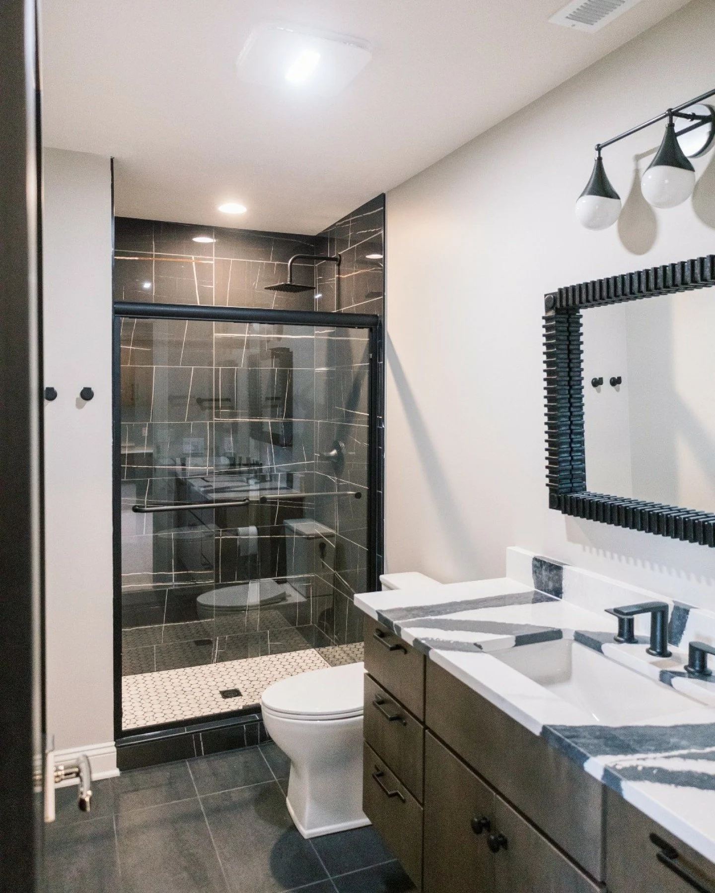 Proof that a boys&rsquo; bathroom can be both durable and design-forward. 🖤

Bold tile, matte black fixtures, and graphic stone details bring a little edge to this space while keeping it practical for everyday life. Because even the most hardworking