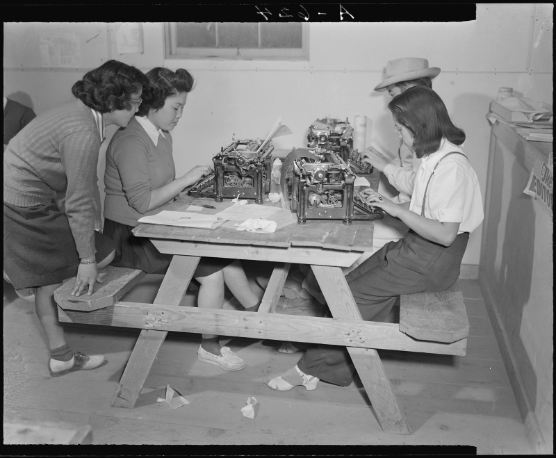 Tule Lake Relocation Center, Newell, California, November 2, 1942. Writers and editors work at the city desk of the Tulean Dispatch, the camp's newspaper. 