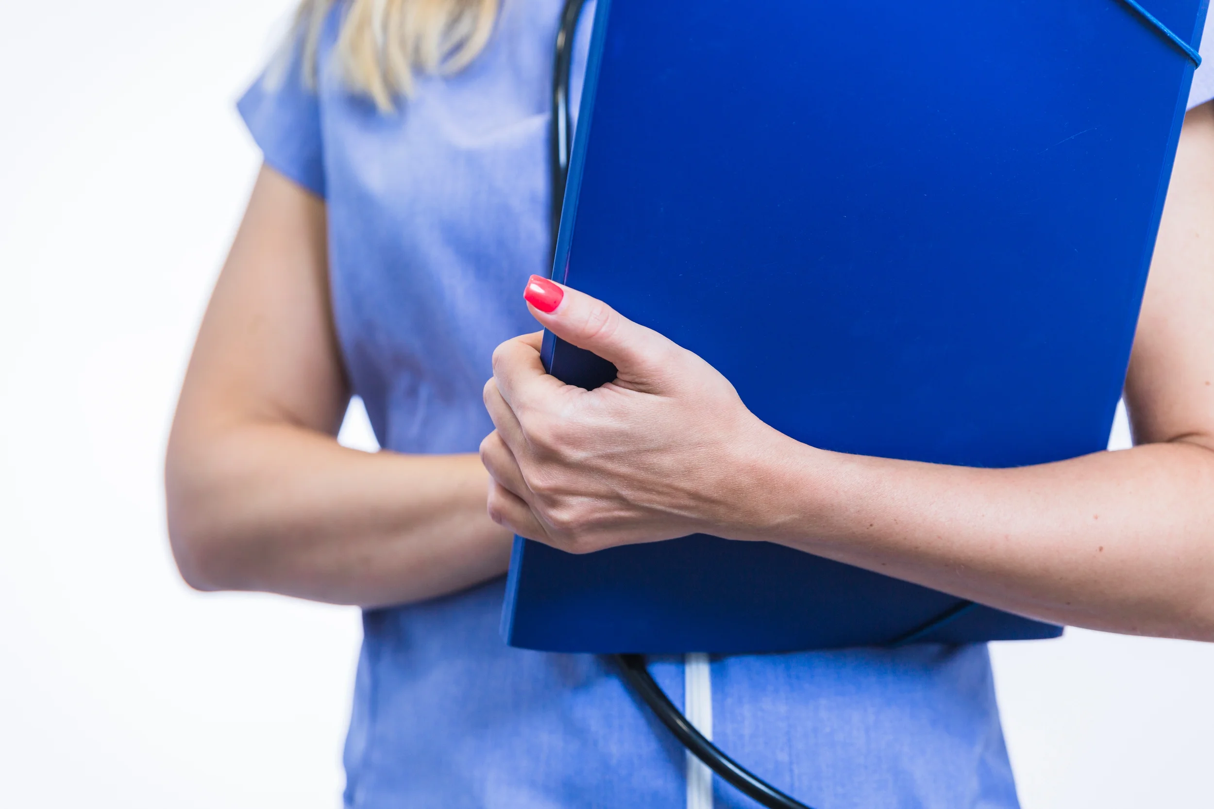 Nurse in blue scrubs holding a folder