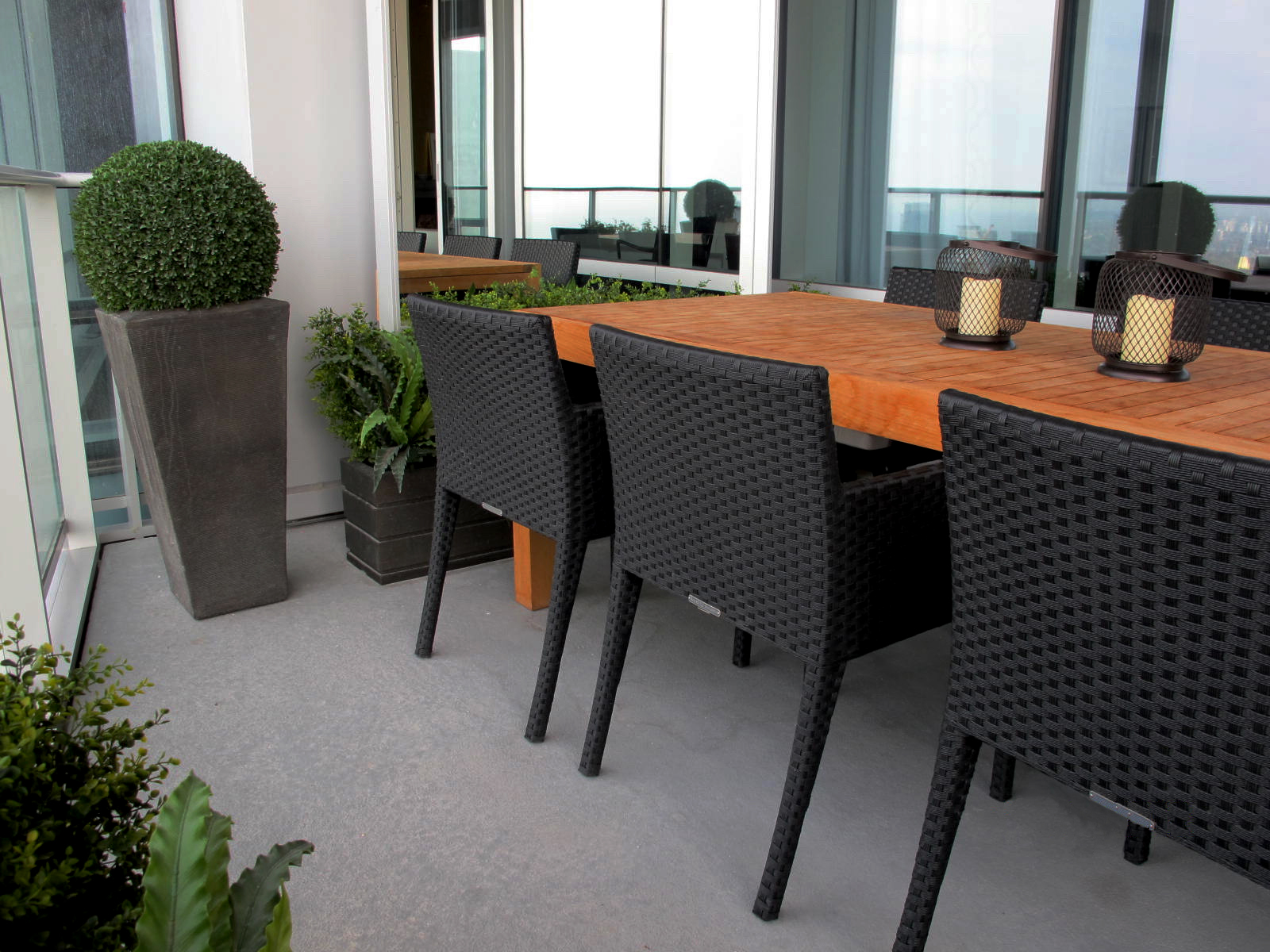  Our Creative Director made this cramped balcony feel expansive by placing a large mirror on the far wall, by the teak dining table. The owners say it has transformed their sense of space beyond the glass, both outside and inside. 