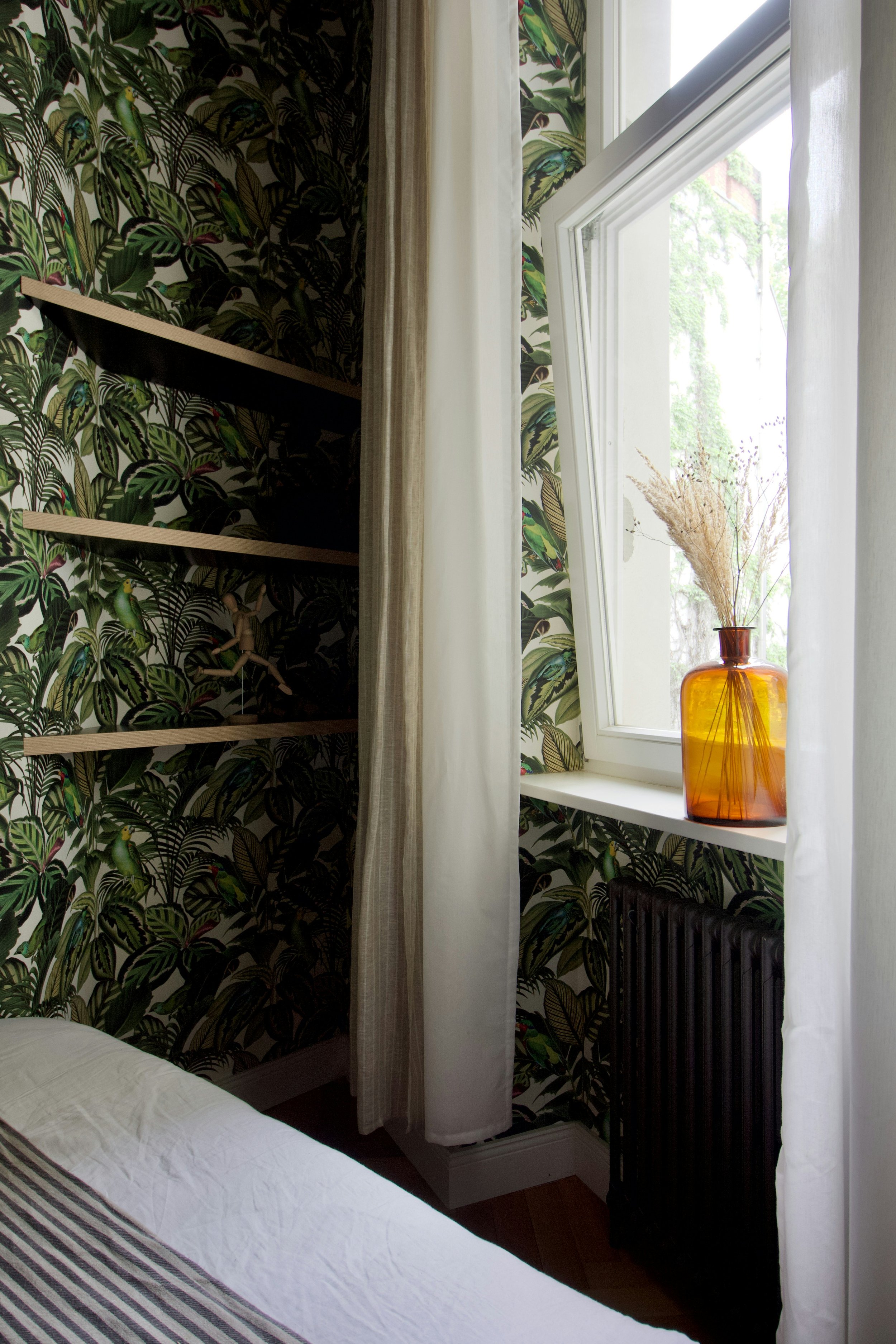 a set of empty wall shelves next to the bed in the guest bedroom