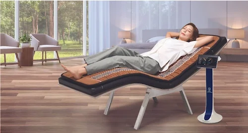 Image featuring a woman relaxing on the Biomat Far Infrared mat with a BioAcoustic Mat underneath as integrative wellness tools.
