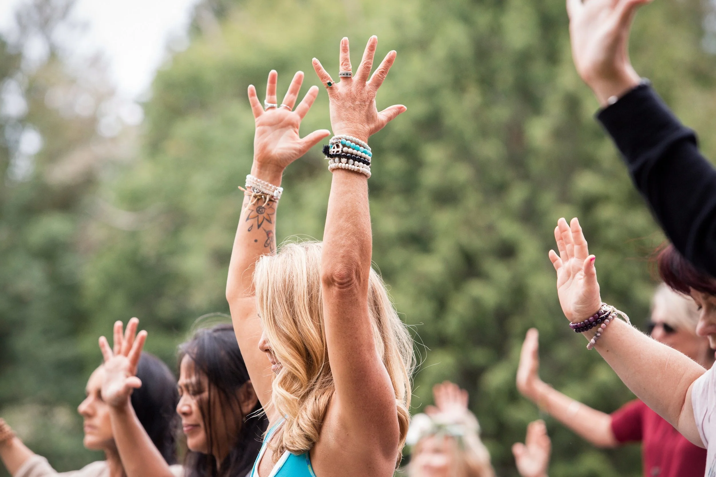 Women raising their hands during the annual outdoor Gathering of Goddesses event in Olympia, Washington.