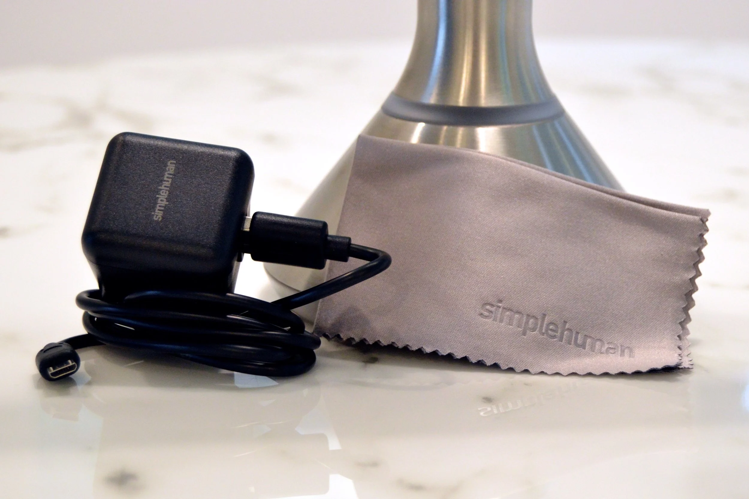 The mirror comes with a USB charging cord, adapter, and a cleaning cloth.