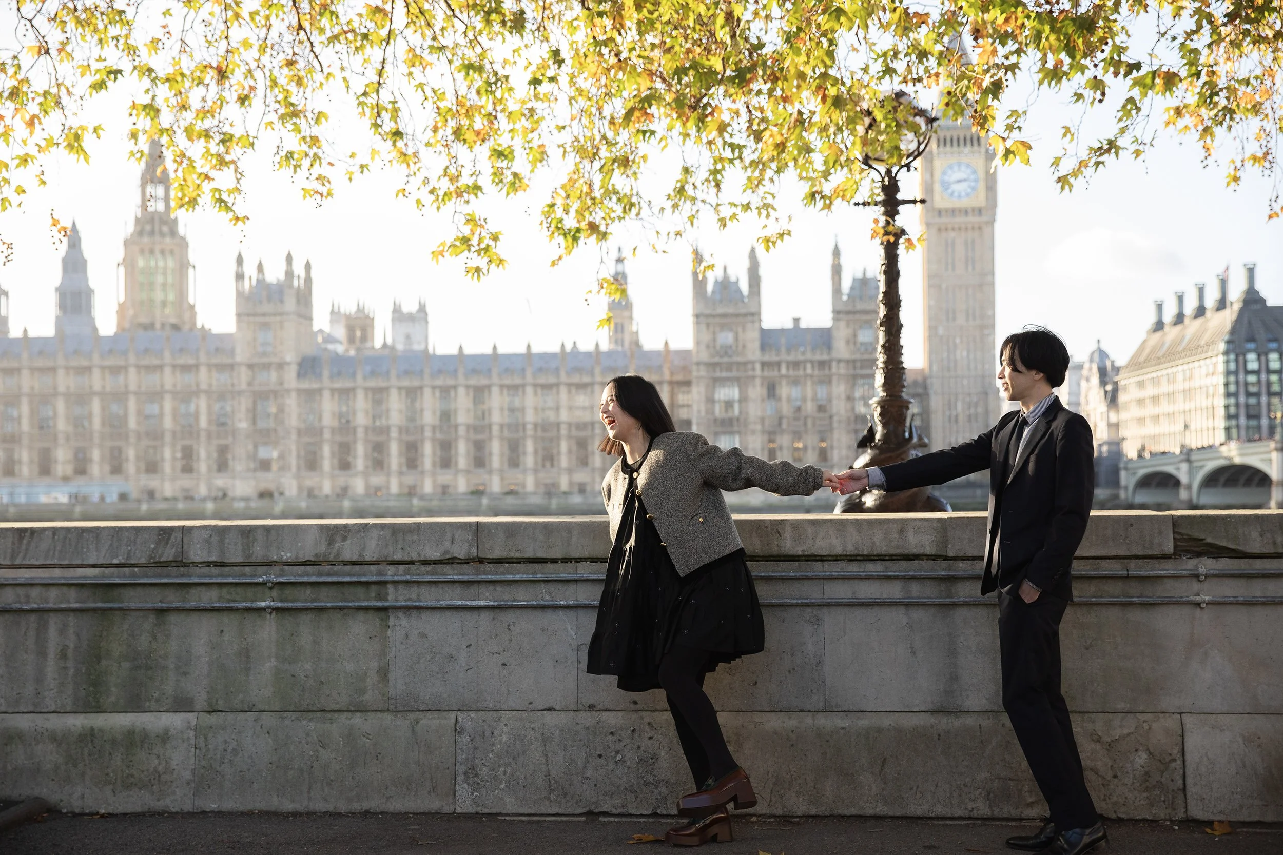 a couple having fun in front of Houses of Parliament