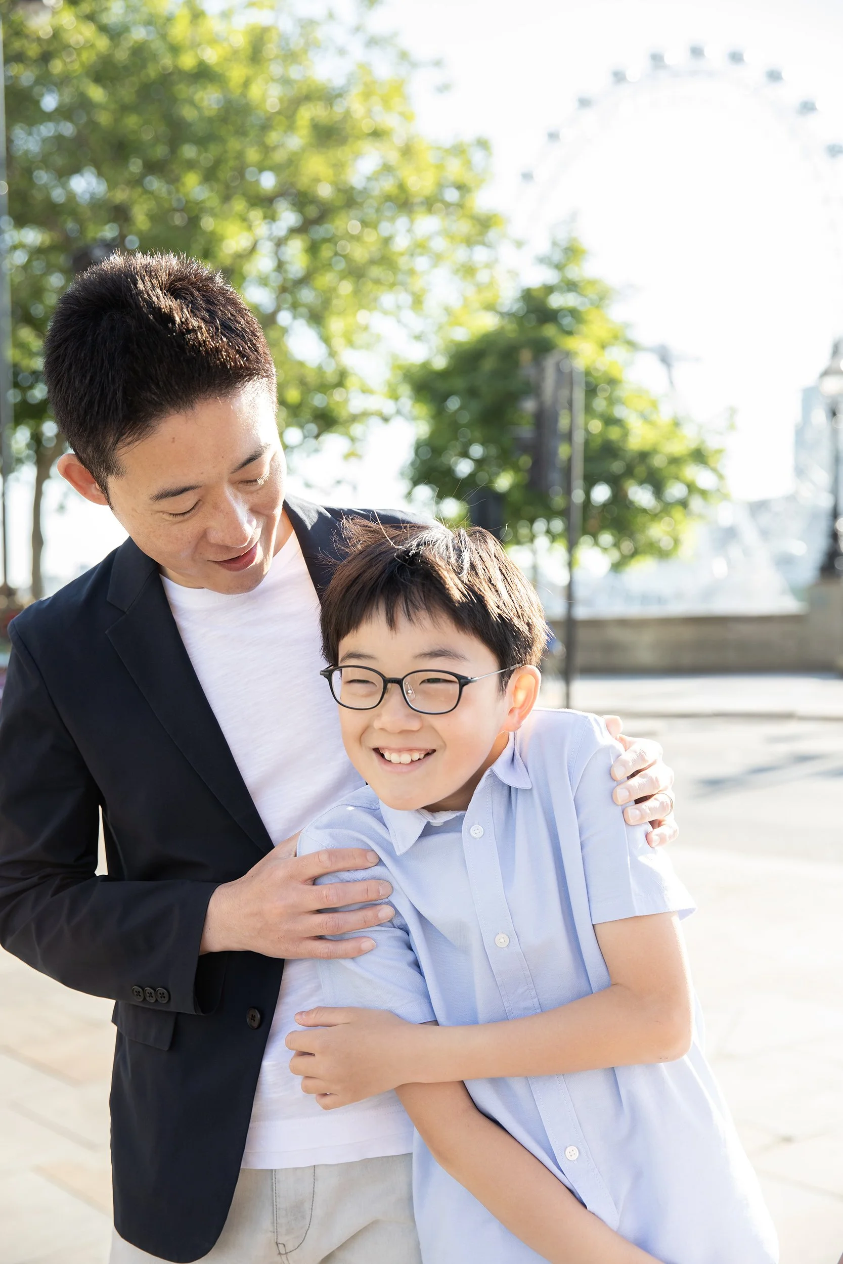 a dad holding his son from behind