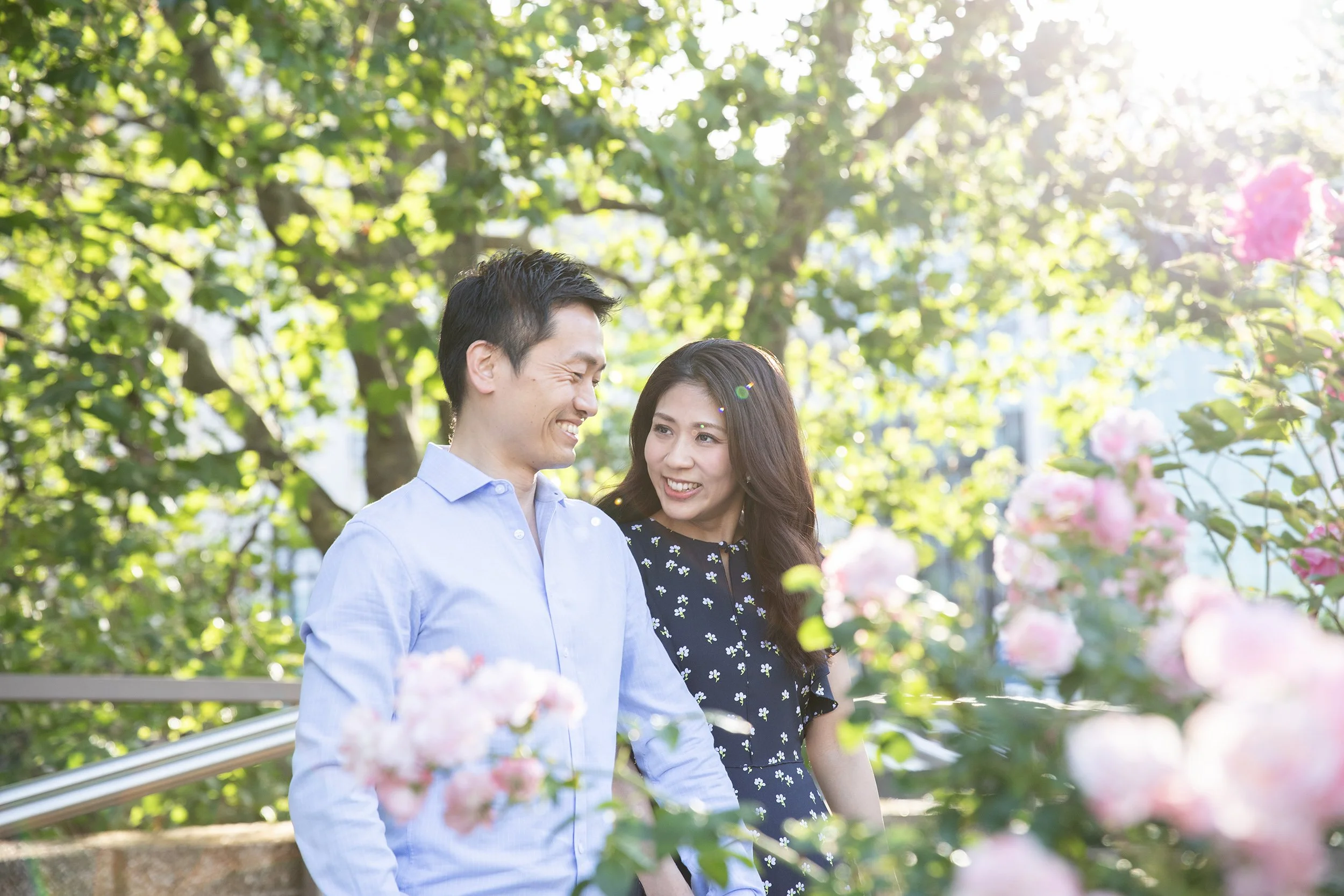 a couple in a garden with flowers in the morning light