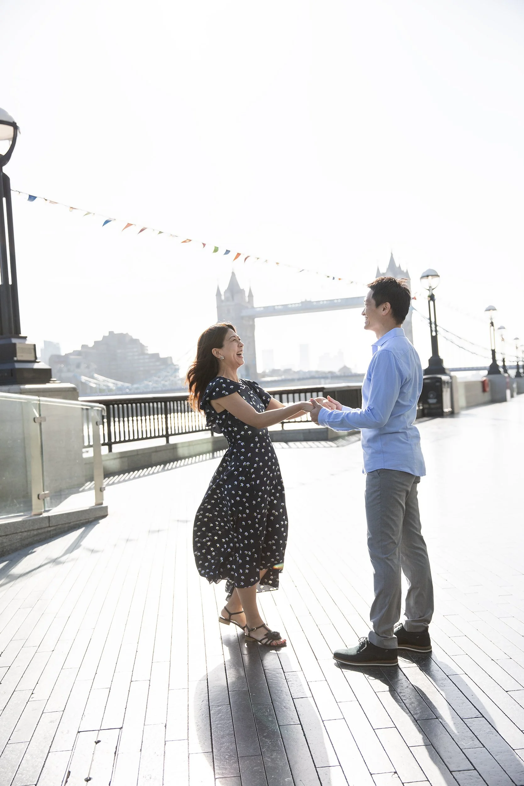 a couple dancing near Tower Bridge in the morning light