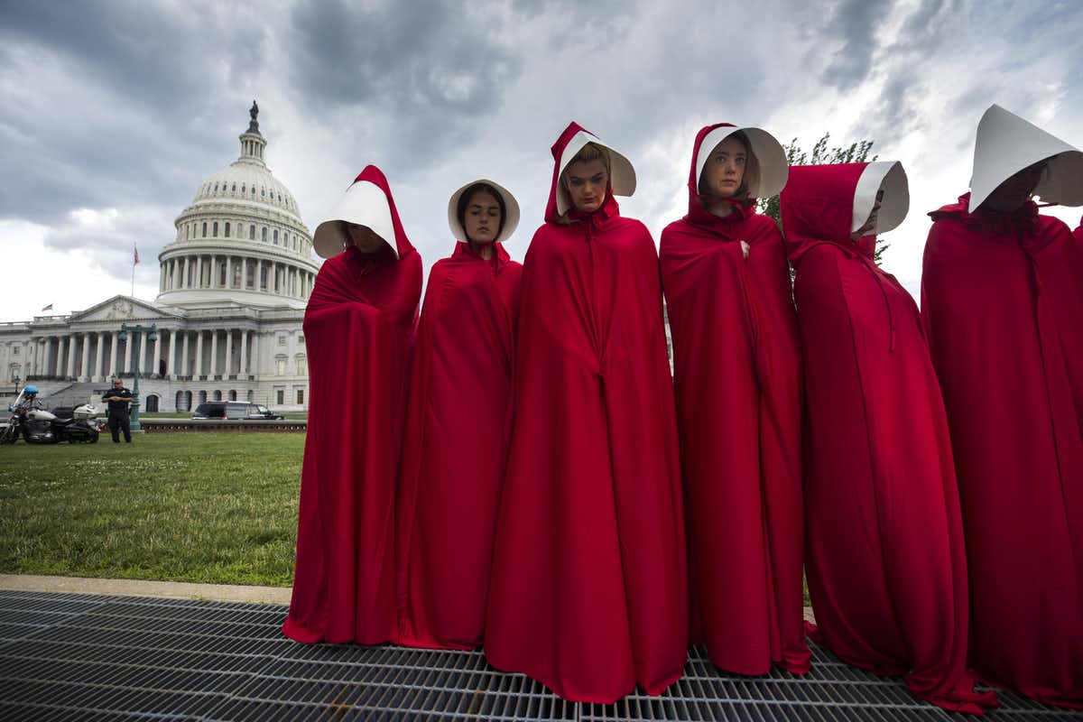 Activists in the U.S. have donned the red cloaks imagined by Margaret Atwood in The Handmaid's Tale . Jim Lo Scalzo/EPA/AAP