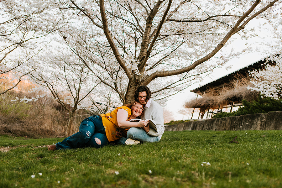 Couple reading a book together under Cherry Blossom Tree at White River State Park photo session