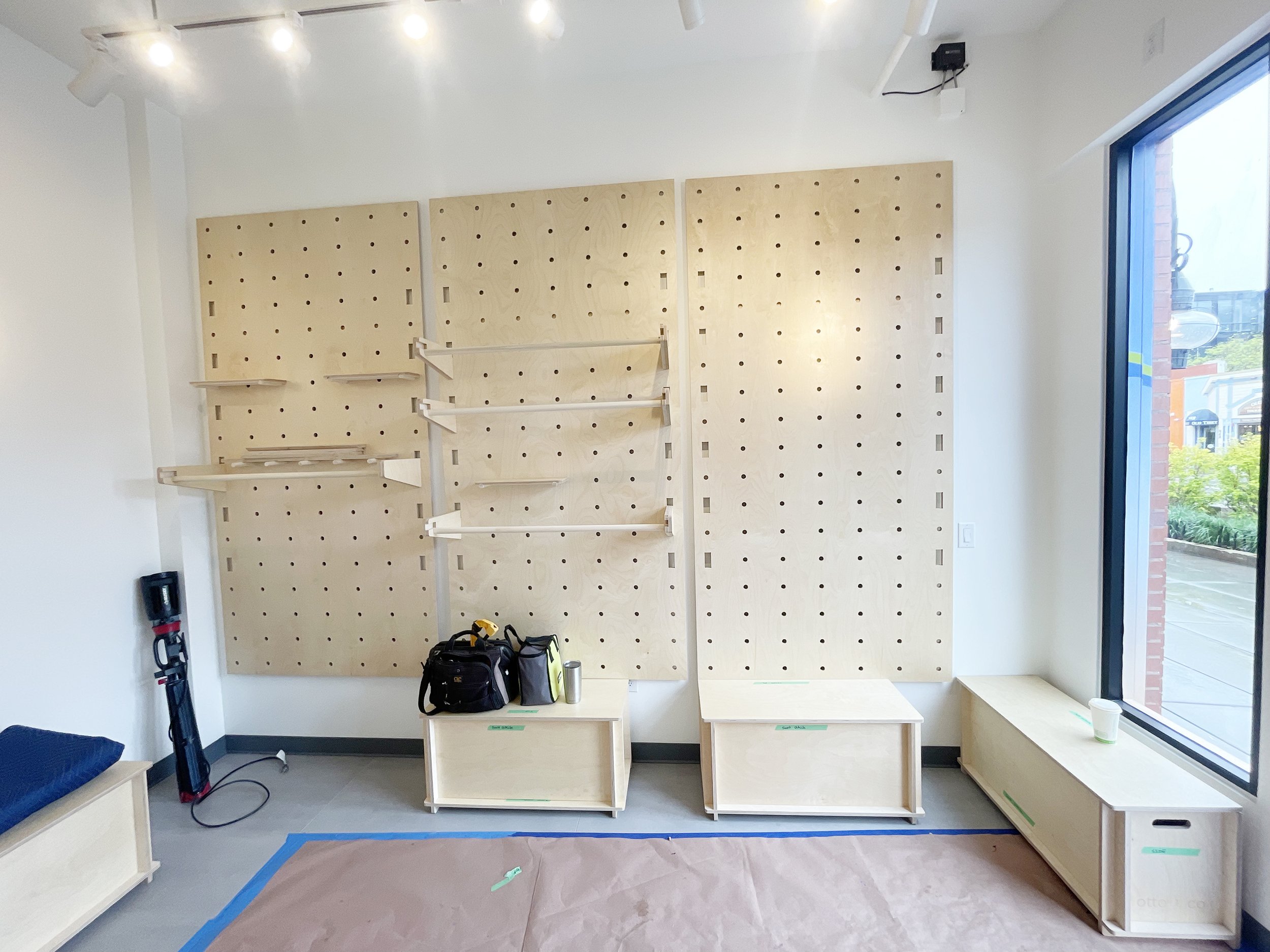 wood pegboard wall with clothing rack