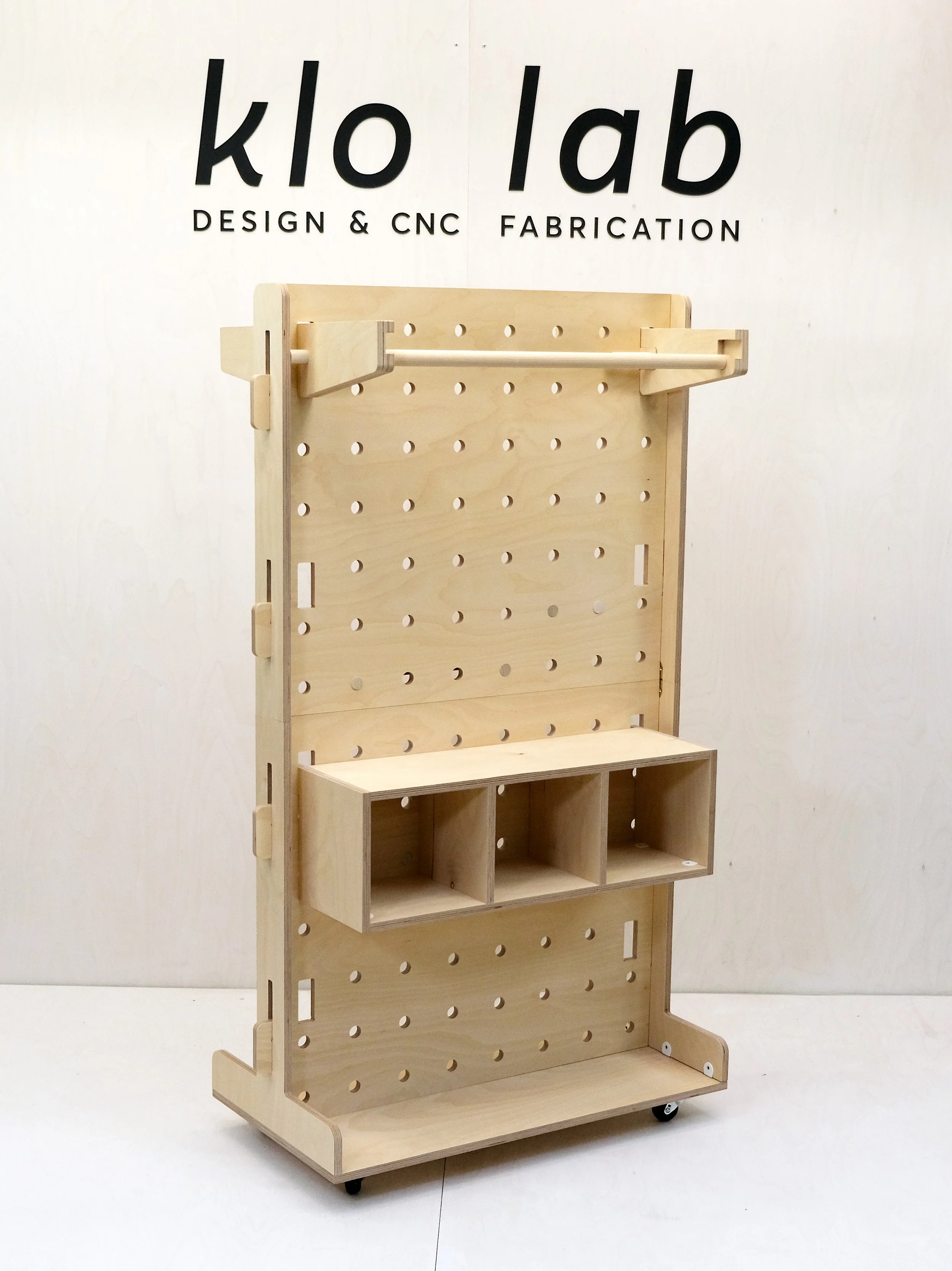 Rolling pegboard retail display on wheels designed to ship flat