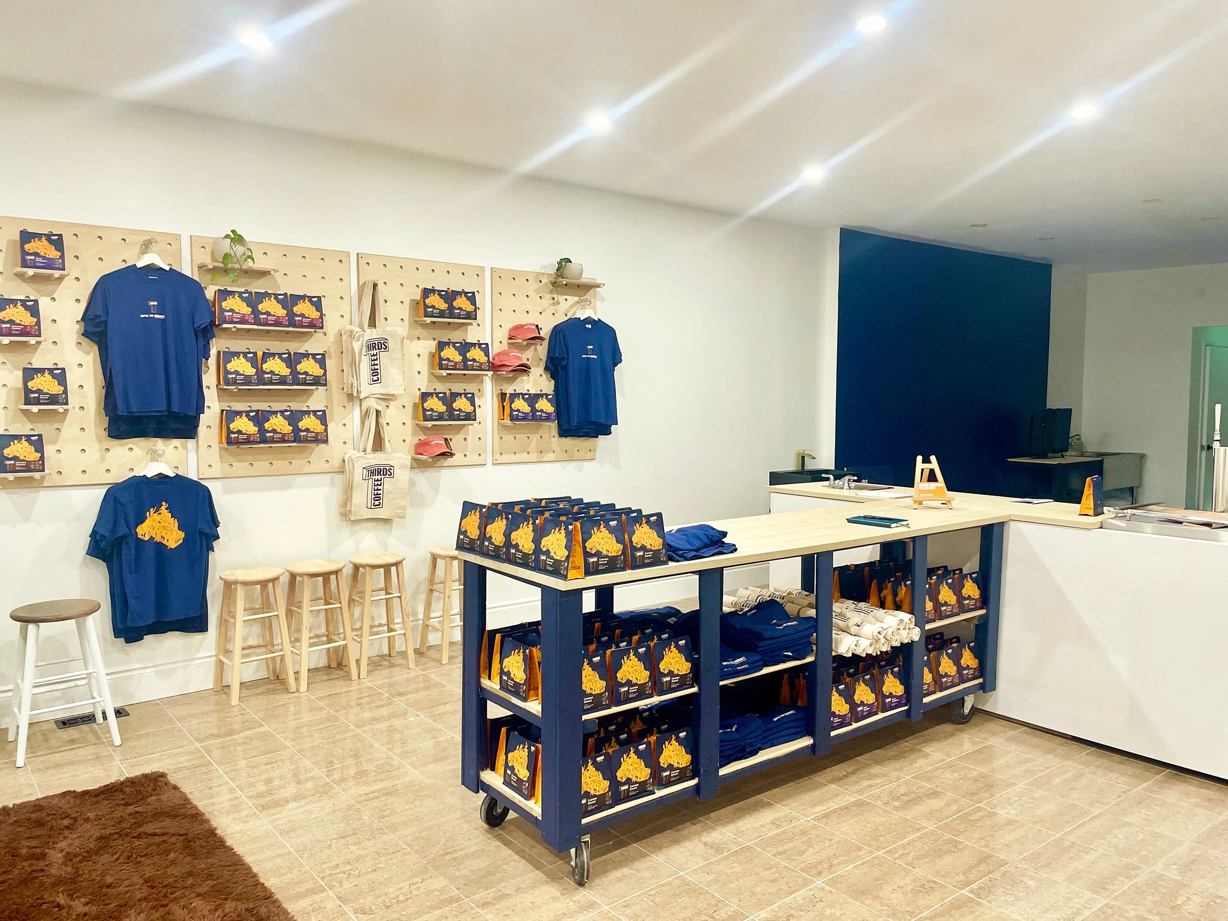 Coffee shop wall with custom wood pegboard and shelves displaying coffee beans and mugs