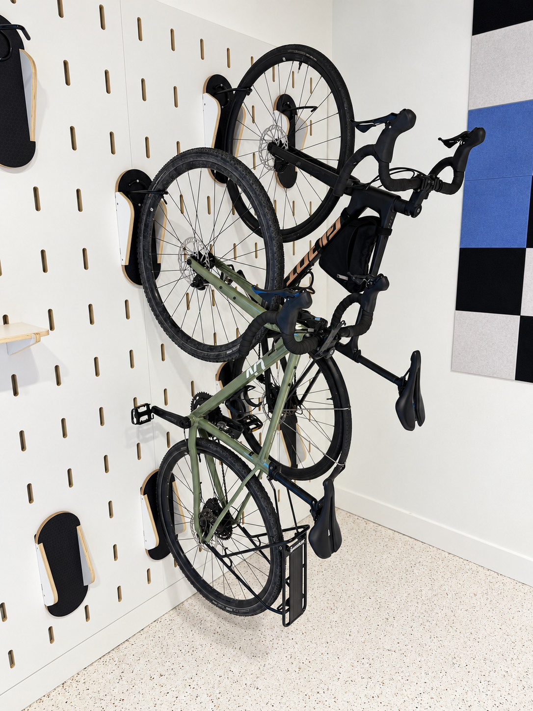 Adjustable bike mount fitted into a custom plywood slot pegboard wall