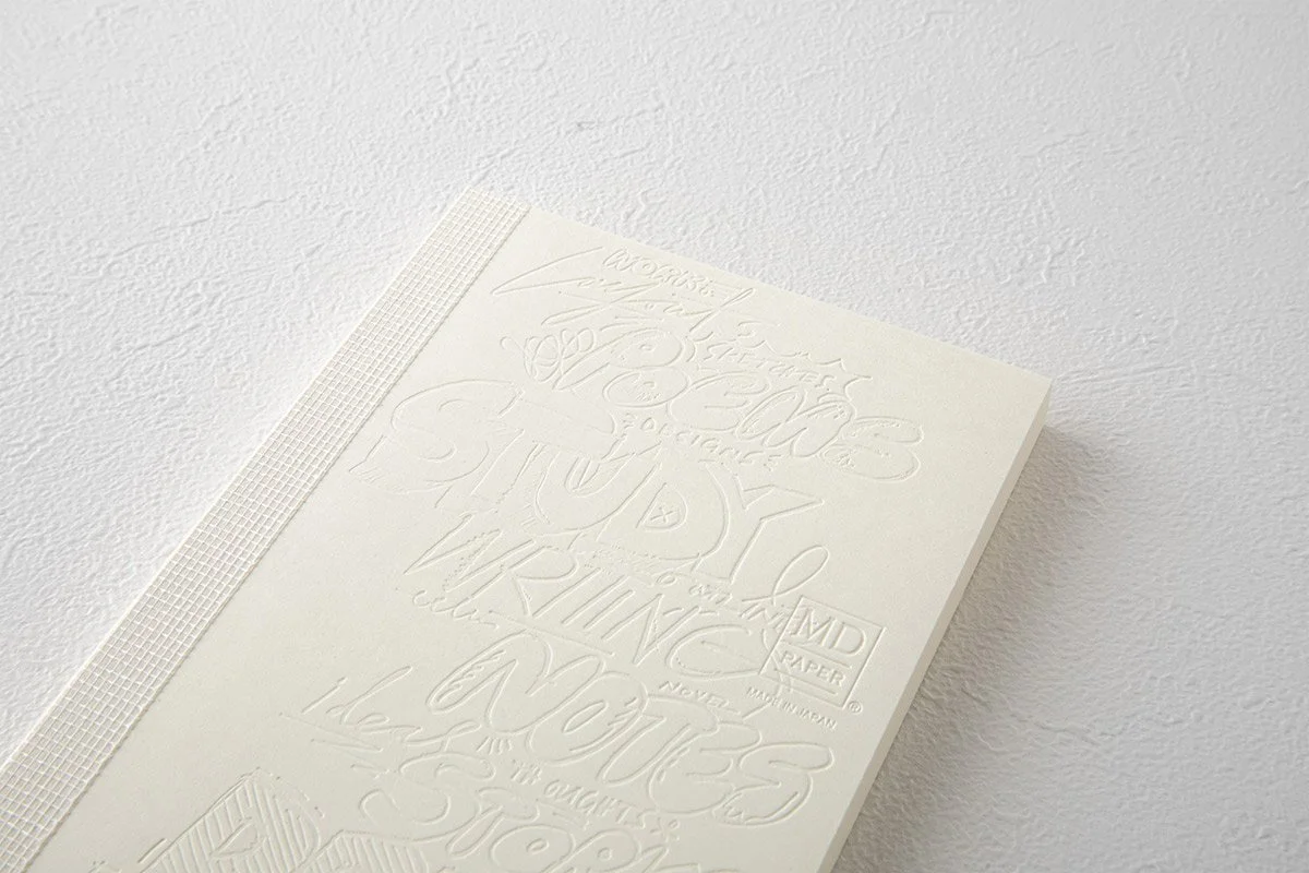 日本を代表する文具メーカーMIDORIが出しているMDノートの15周年を記念して、国内外で活躍する15名のアーティストたちによる周年記念ノートが発売になりました。弊社ではその中の11名をキュレーションさせていただきました。アーティストが『MDノート』の表紙に描いたイラストや文字を、空押しで再現した特別なノートとなっています。                                     We teamed up with authentic stationary brand calle