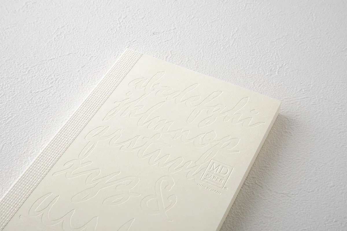 日本を代表する文具メーカーMIDORIが出しているMDノートの15周年を記念して、国内外で活躍する15名のアーティストたちによる周年記念ノートが発売になりました。弊社ではその中の11名をキュレーションさせていただきました。アーティストが『MDノート』の表紙に描いたイラストや文字を、空押しで再現した特別なノートとなっています。                                     We teamed up with authentic stationary brand calle