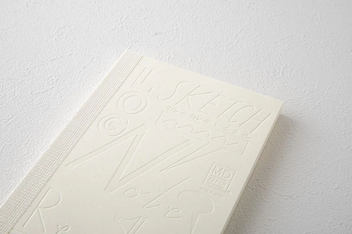 日本を代表する文具メーカーMIDORIが出しているMDノートの15周年を記念して、国内外で活躍する15名のアーティストたちによる周年記念ノートが発売になりました。弊社ではその中の11名をキュレーションさせていただきました。アーティストが『MDノート』の表紙に描いたイラストや文字を、空押しで再現した特別なノートとなっています。                                     We teamed up with authentic stationary brand calle
