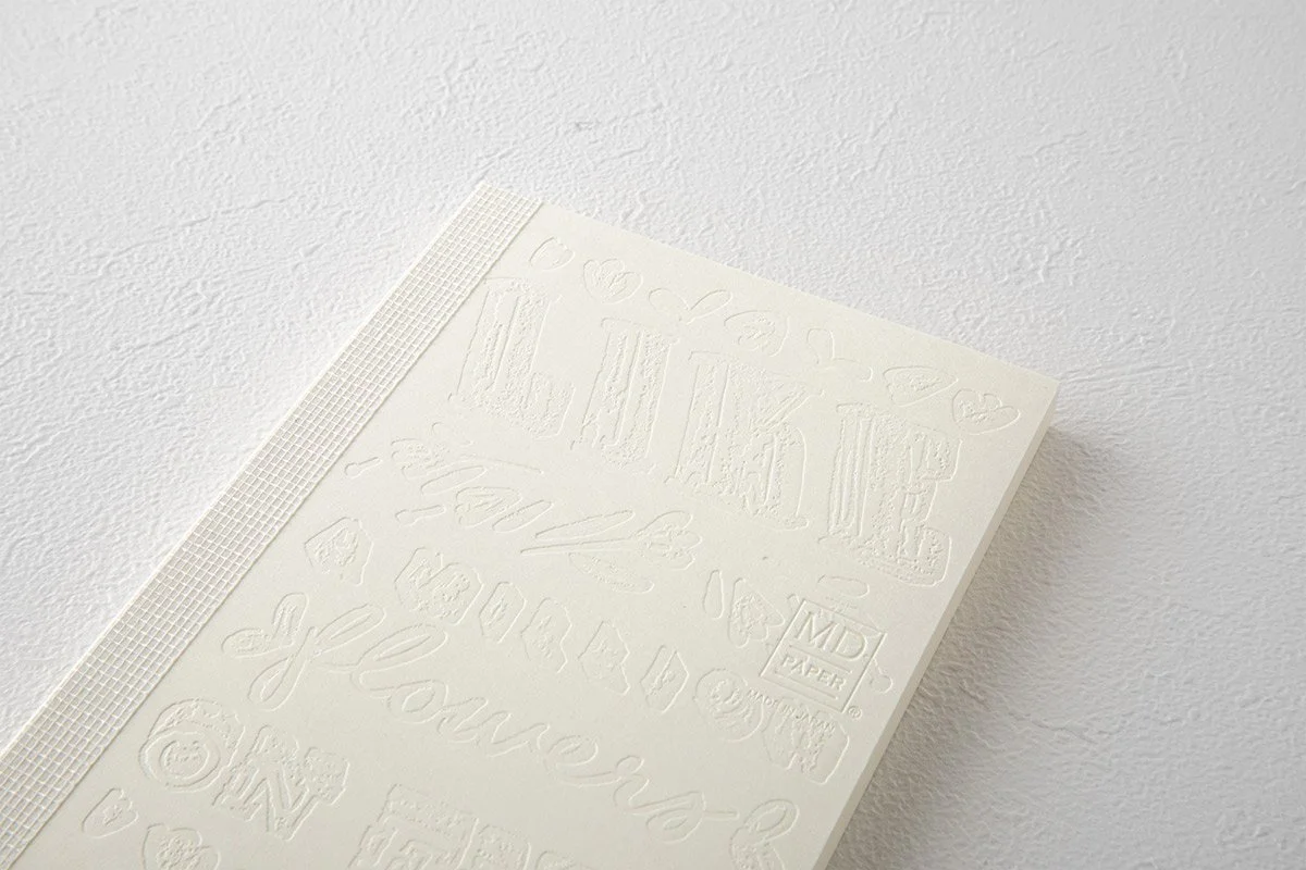 日本を代表する文具メーカーMIDORIが出しているMDノートの15周年を記念して、国内外で活躍する15名のアーティストたちによる周年記念ノートが発売になりました。弊社ではその中の11名をキュレーションさせていただきました。アーティストが『MDノート』の表紙に描いたイラストや文字を、空押しで再現した特別なノートとなっています。                                     We teamed up with authentic stationary brand calle