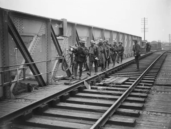British troops crossing over a Merville railway bridge that has been primed with explosives in case the bridge needs to be destroyed, 11 April 1918.