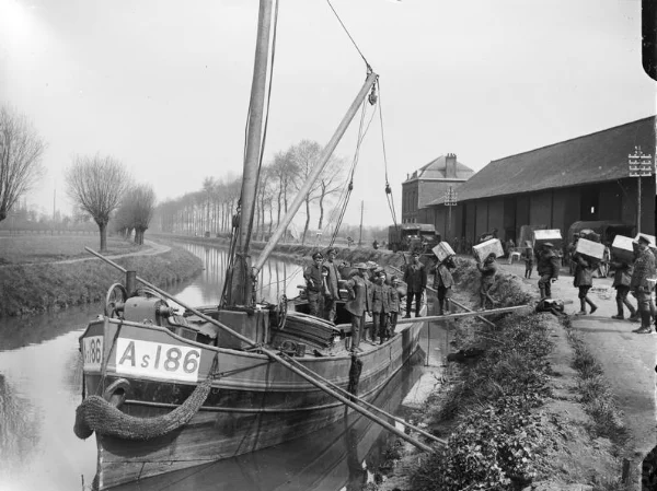 Men loading stores and munitions onto a barge on the canal at Merville to prevent them falling into German hands, 11 April 1918.