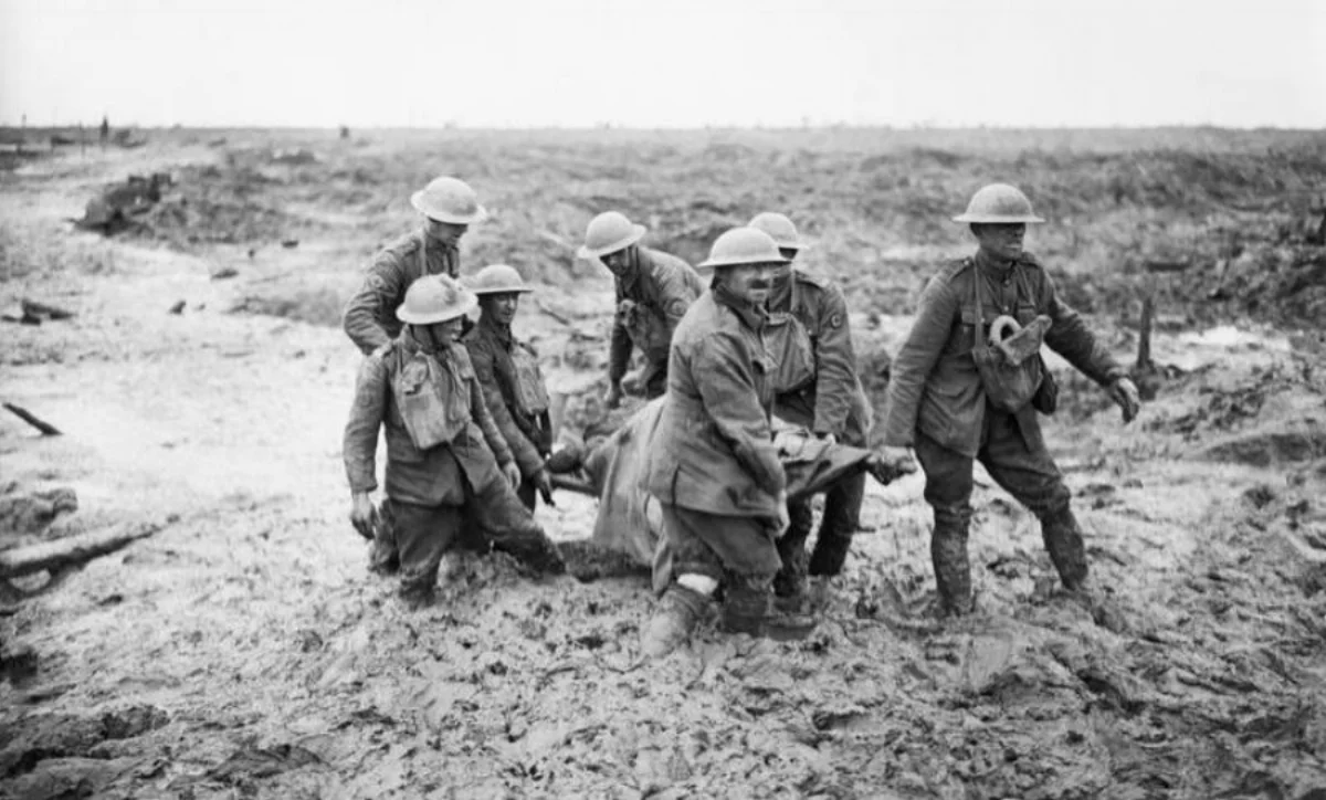 A team of stretcher bearers struggle through deep mud to carry a wounded man to safety during the Third Battle of Ypres.