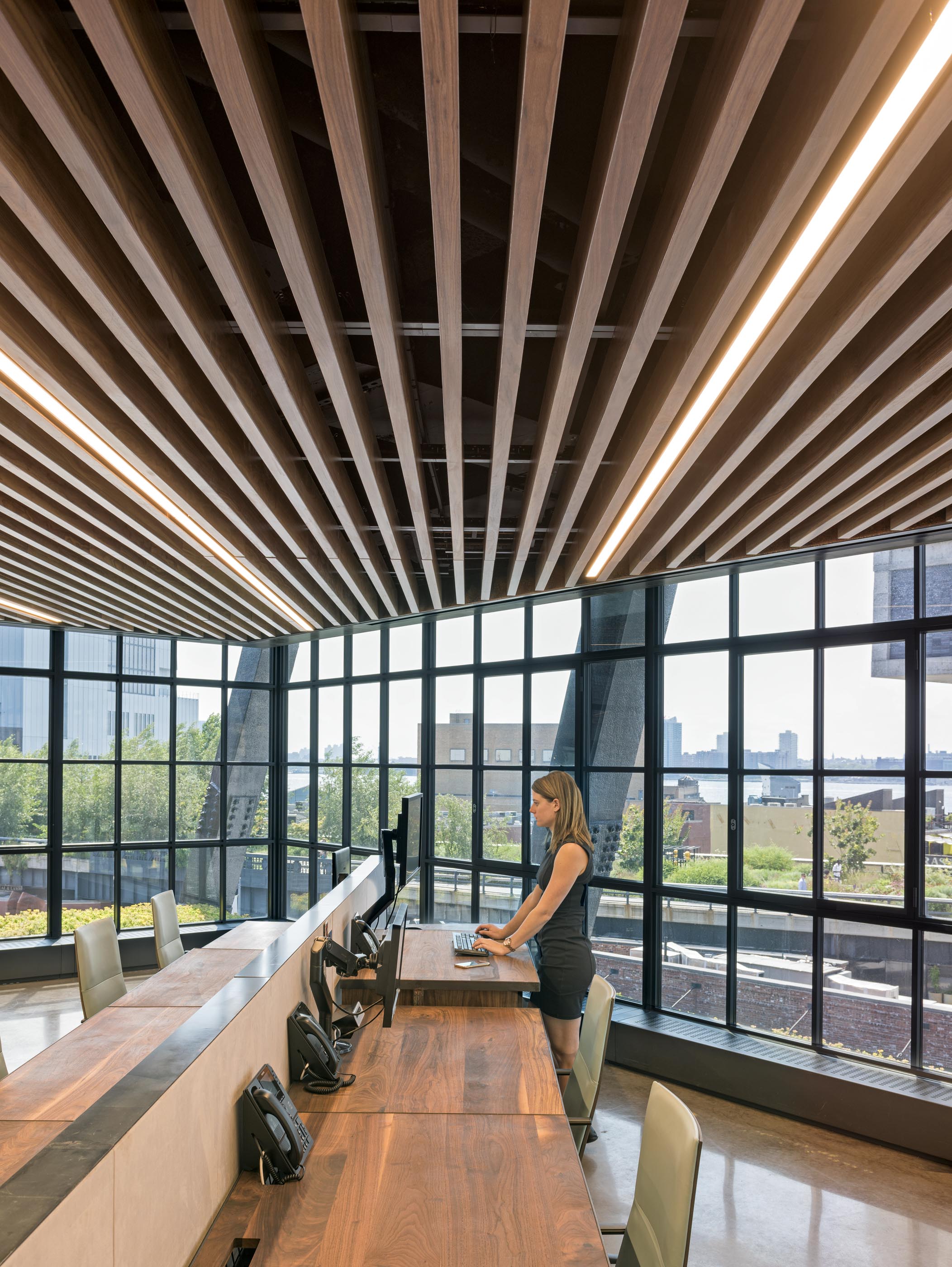 “Instead of sticking to classic orthogonal planning, we cranked everything askew,” Burry explains. Walnut ceiling slats and runs of workstations are arrayed diagonally, directing eyes to Hudson River views through full-height glazing. Said workstations are height-adjustable via a hand crank that the designer says “had the right industrial feeling so it doesn’t look like typical corporate-tech office furniture.” Leaning more residential is the wedge-shaped lounge bordered by mid-century-esque custom cabinets at every floor’s center. “We wanted to make the space feel like Samsung,” says company retail designer Eslam Khalil, “without slapping the logo everywhere, or deploying supercrazy colors or features like slides. That’s just not Samsung.” The office is, however—to a T.