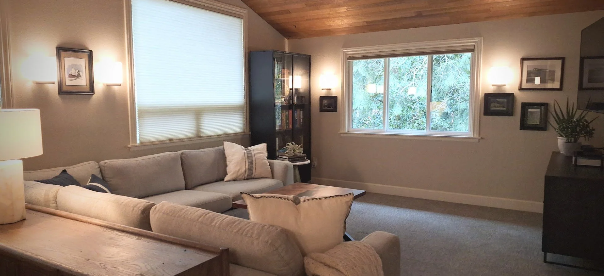 Family room with Four Hands furniture, wood plank ceiling, custom sycamore epoxy coffee table, and large windows.
