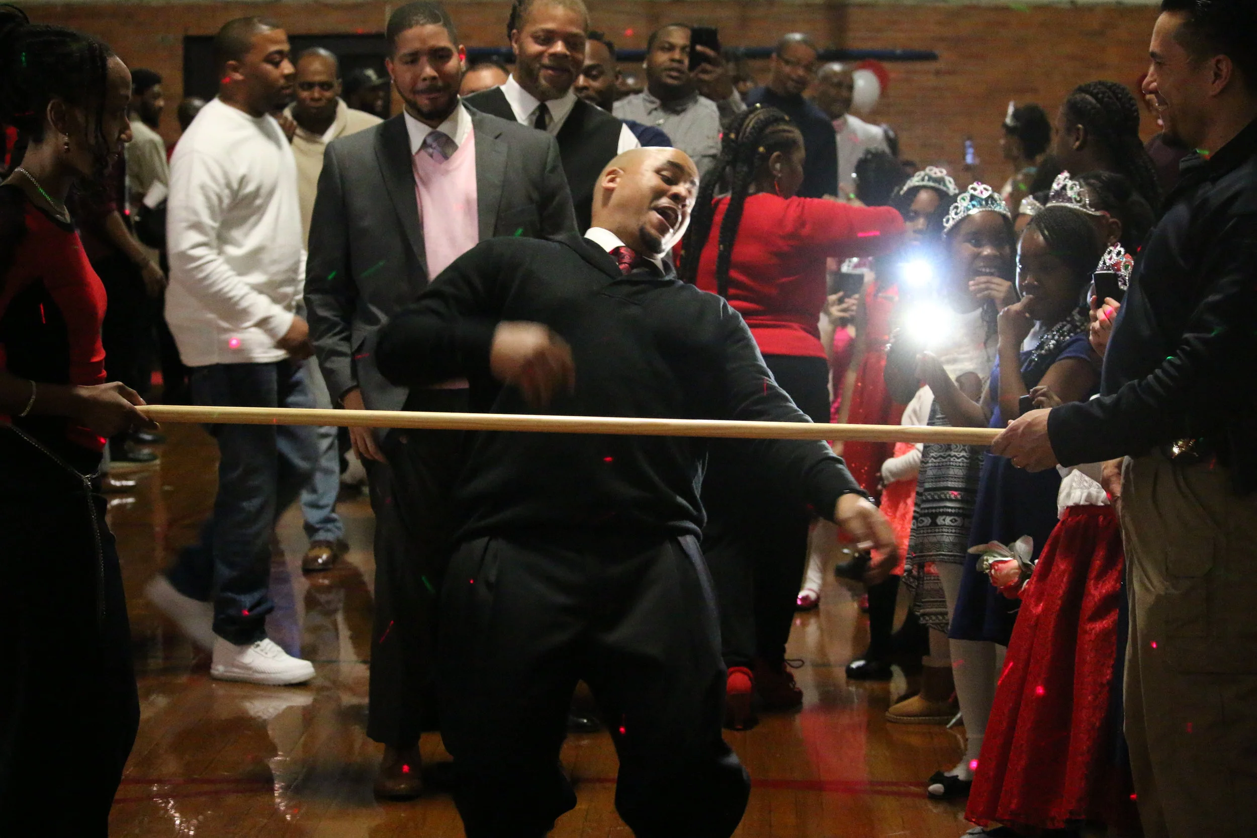 Shem Johnson, of Calumet City, prepares to go underneath the pole during a limbo competition for the dads at a father-daughter dance at Memorial Park on Feb. 12, 2017 in Calumet City.