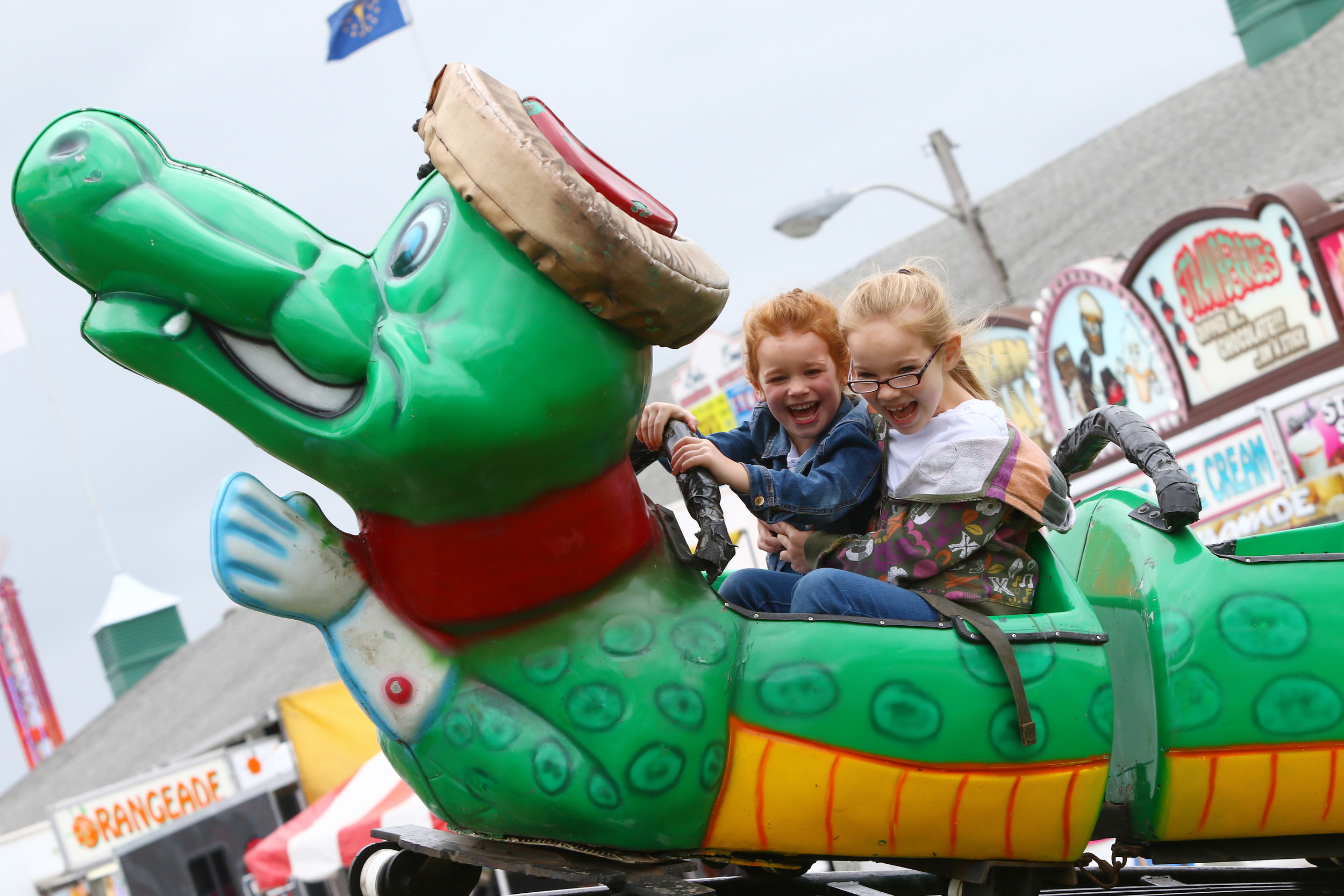 Emma Crnkovich, right, of Hebron, clings onto Caroline Furman, also of Hebron, as they ride the Go Gator during the opening day for the Lake County Fair in Crown Point, Indiana.