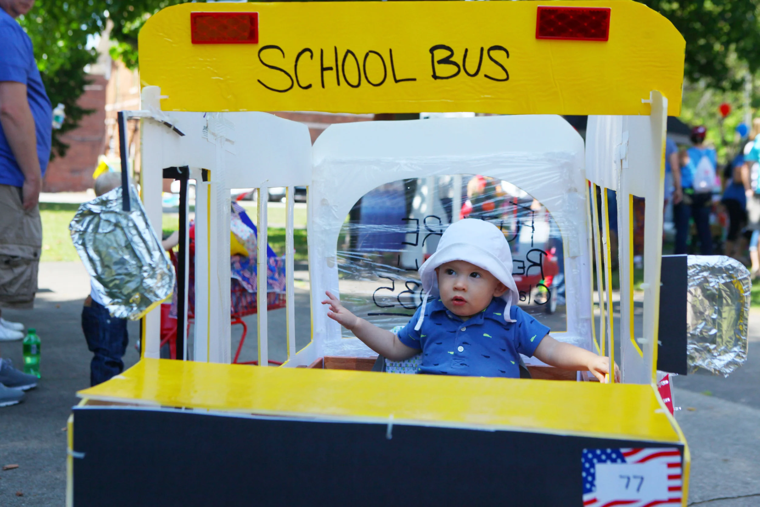 Corey Miller, of Schneider, sits in a school bus-themed wagon before the beginning of the Lowell Kiddie Parade.