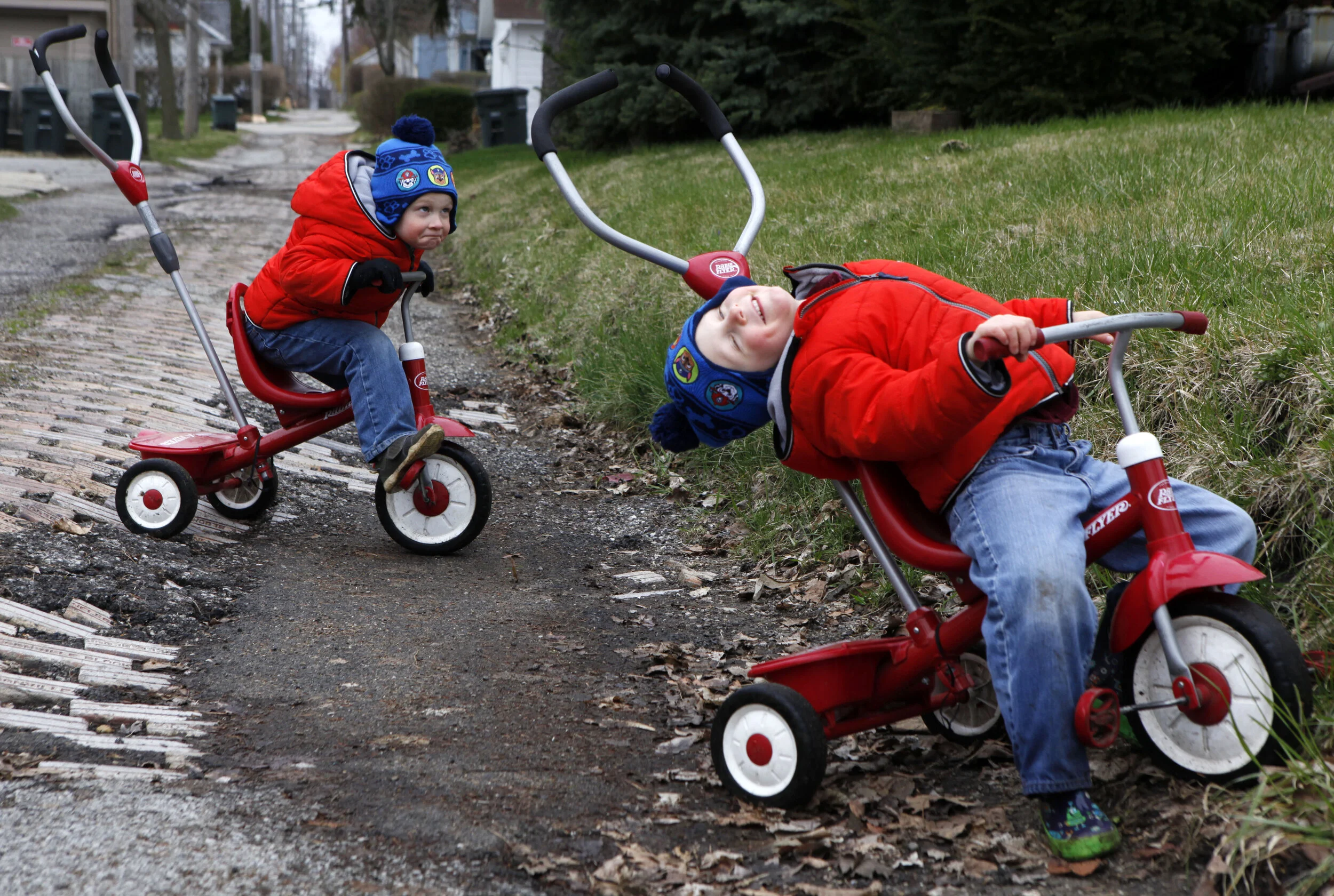 Twins Jonathan, left, and David Schmidt, of Valparaiso, enjoy some time outside on their tricycles in an alleyway on April 4, 2020 in Valparaiso.