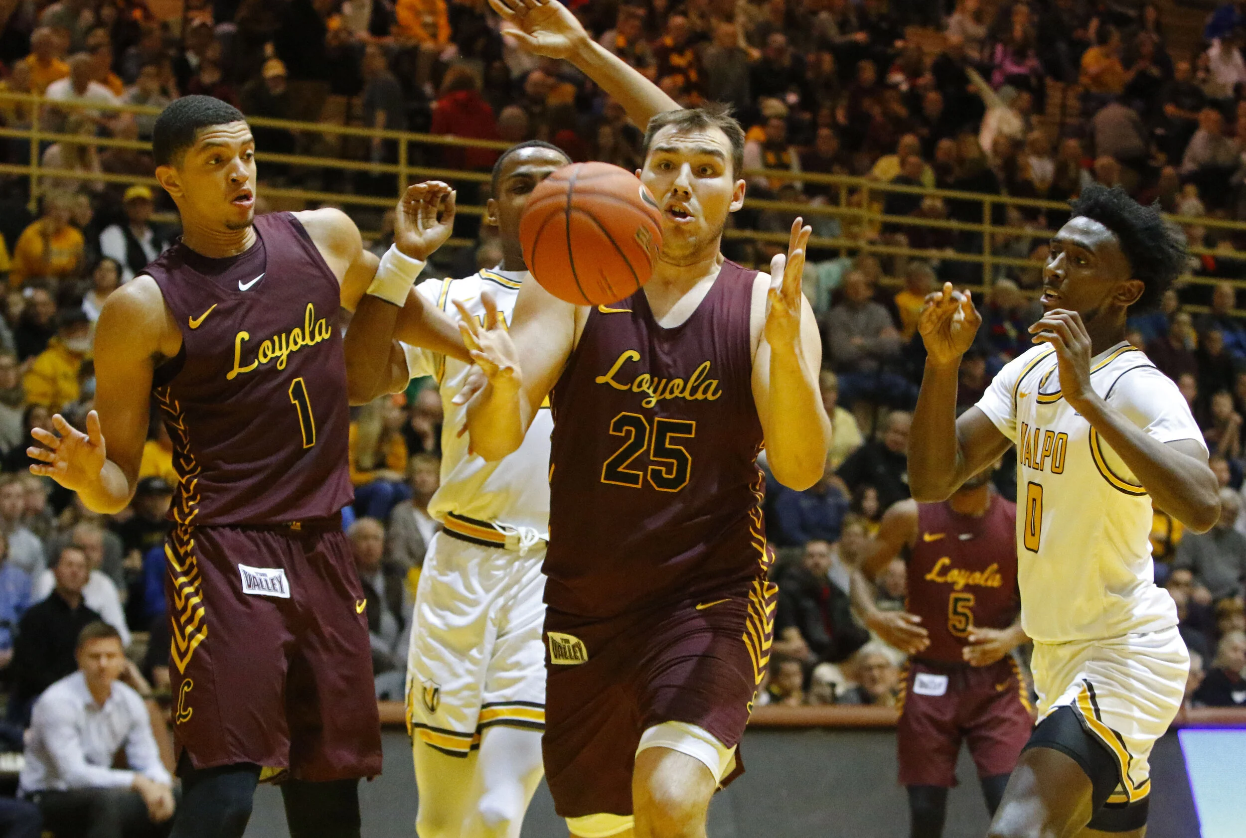 Loyola’s Lucas Williamson, left, and Valparaiso’s Javon Freeman-Liberty, right, watch as Loyola’s Cameron Krutwig tries to grab a rebound Dec. 30, 2019 at the Athletics-Recreation Center.