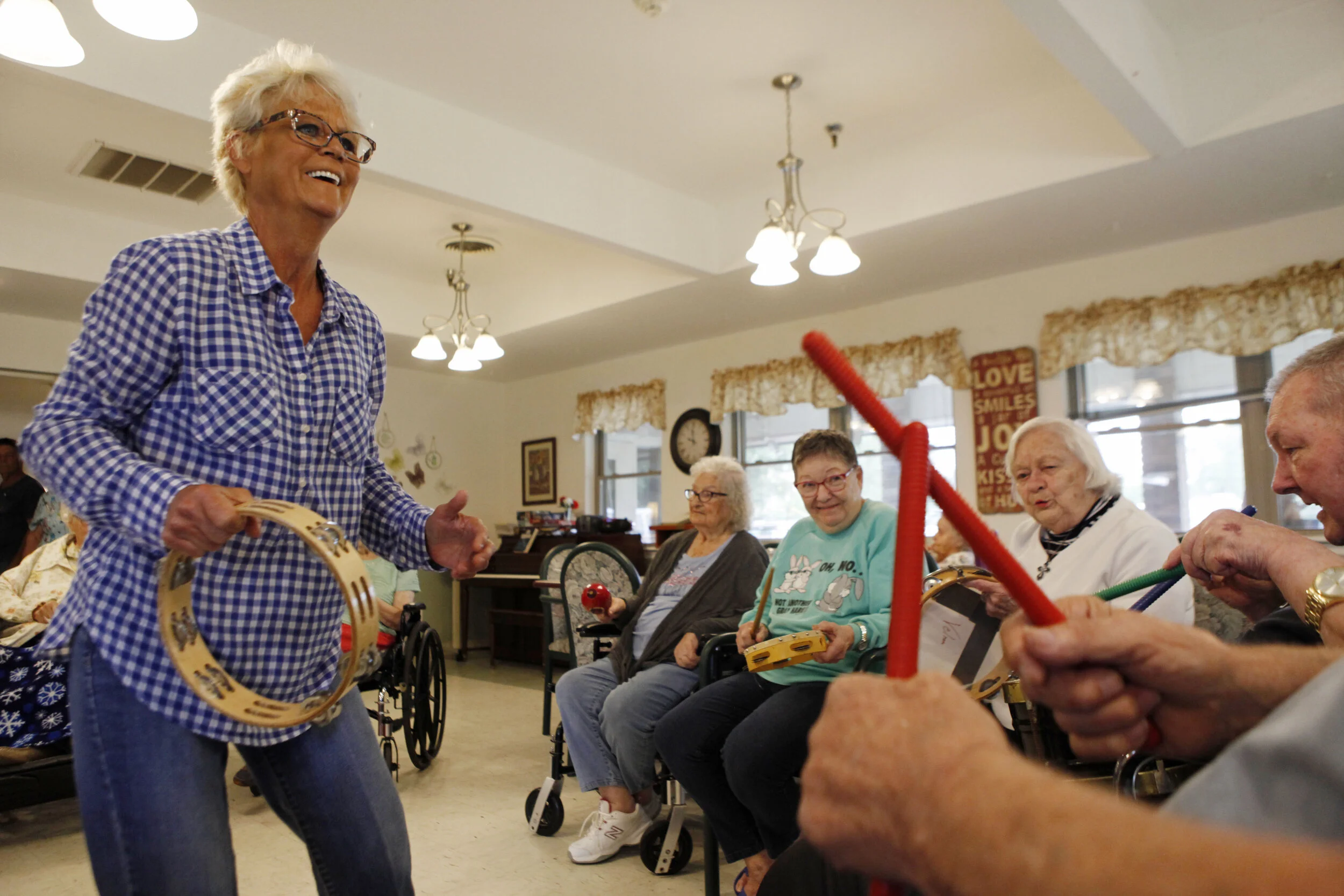  Velma Lang, left, dances and jams with residents at Riverdell Care Center in Boonville, Missouri. Lang organizes several genres of events for the nursing home’s occupants as the activity director. 