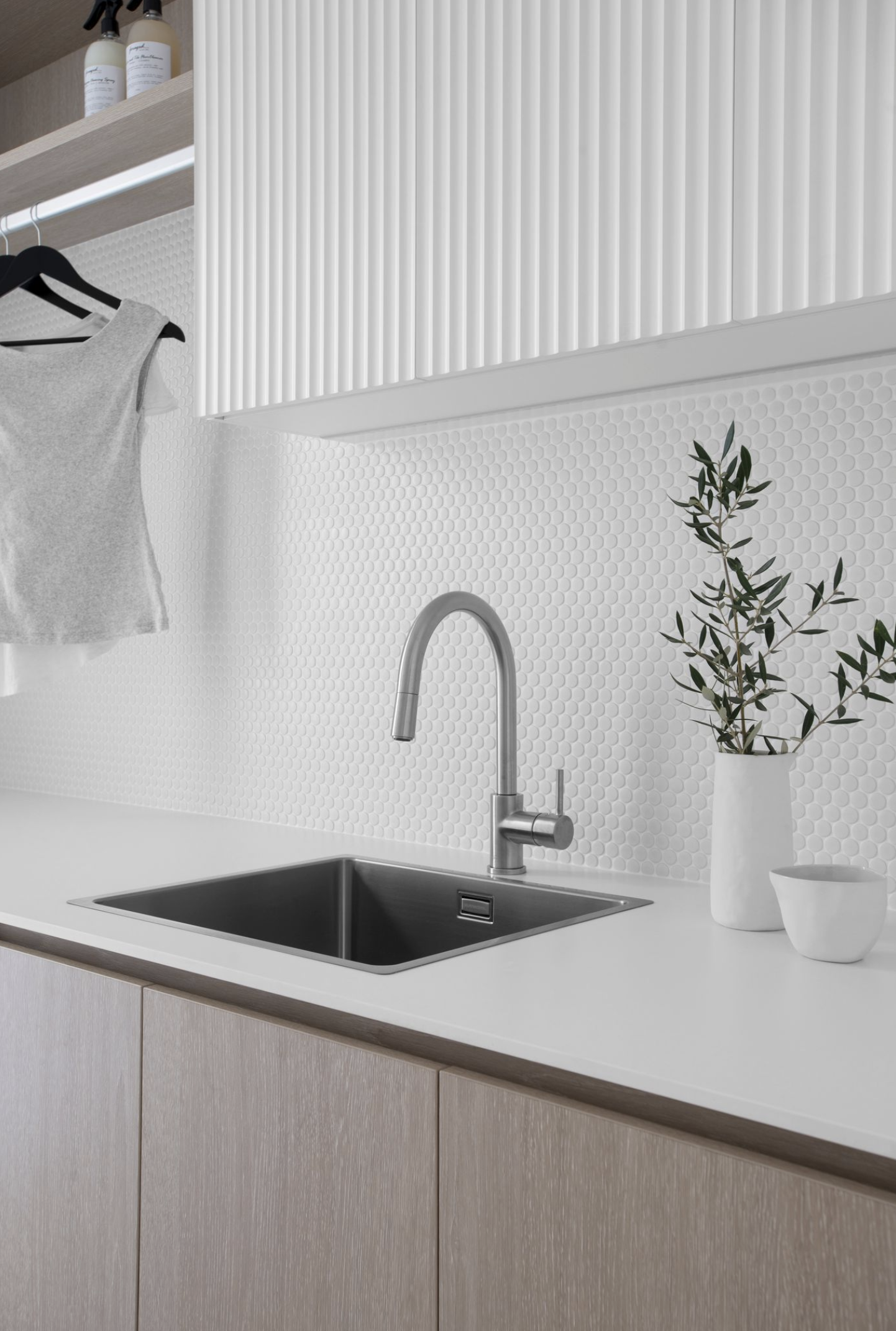 Silver faucet in laundry sink with two plan pot on the counter in Contemporary coastal laundry design plan for laundry renovation