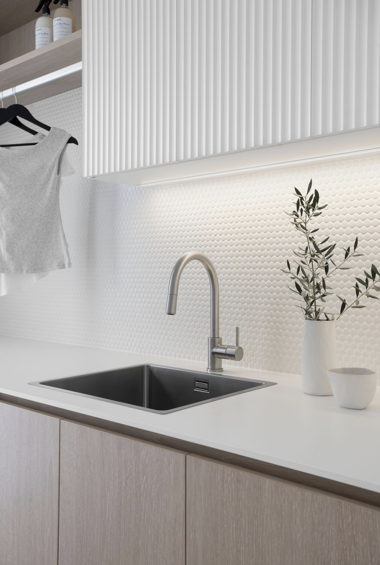 Silver faucet in laundry sink with two plan pot on the counter in Contemporary coastal laundry design plan for laundry renovation