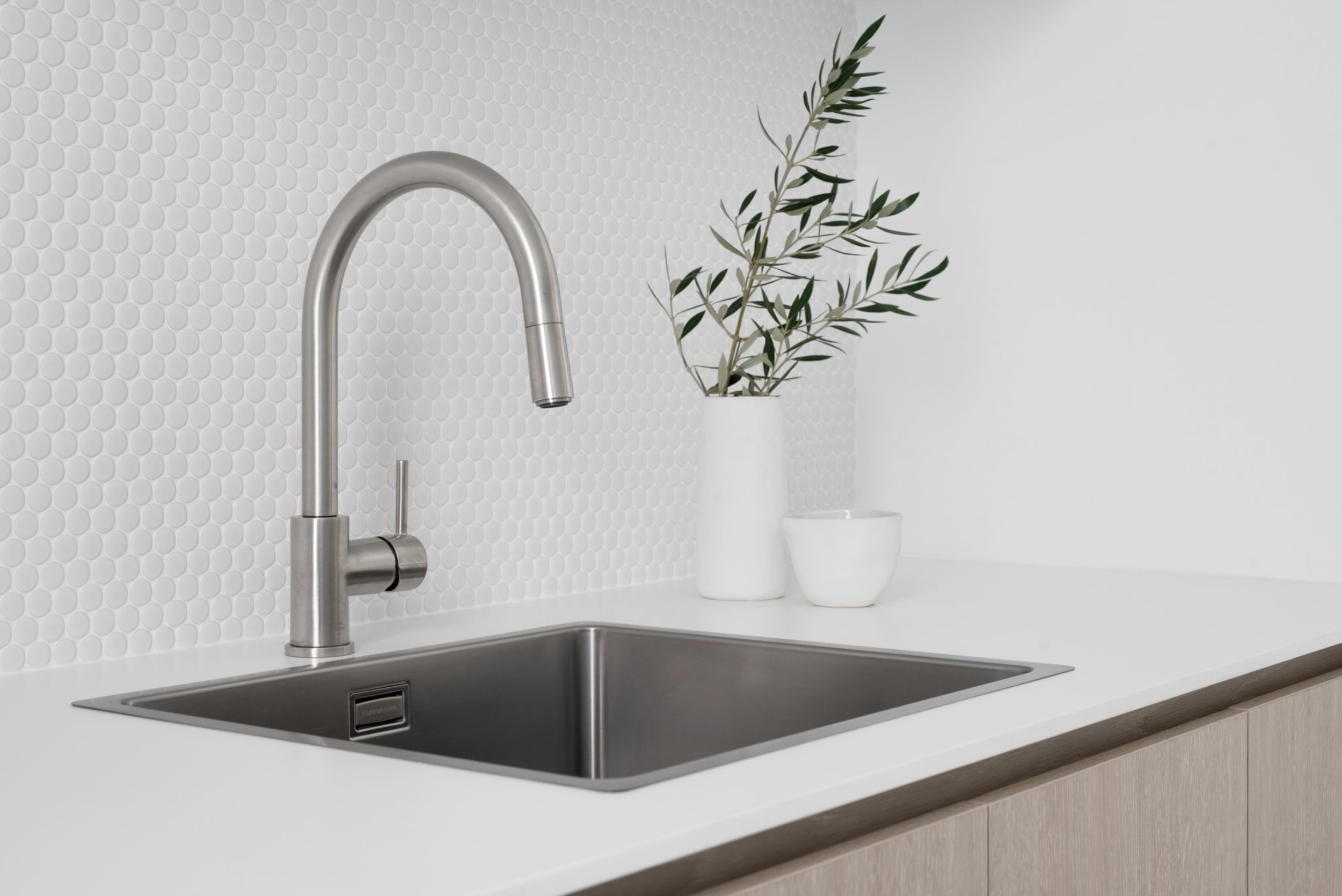 Silver faucet in laundry sink with two plan pot on the counter in Contemporary coastal laundry design plan for laundry renovation Brisbane
