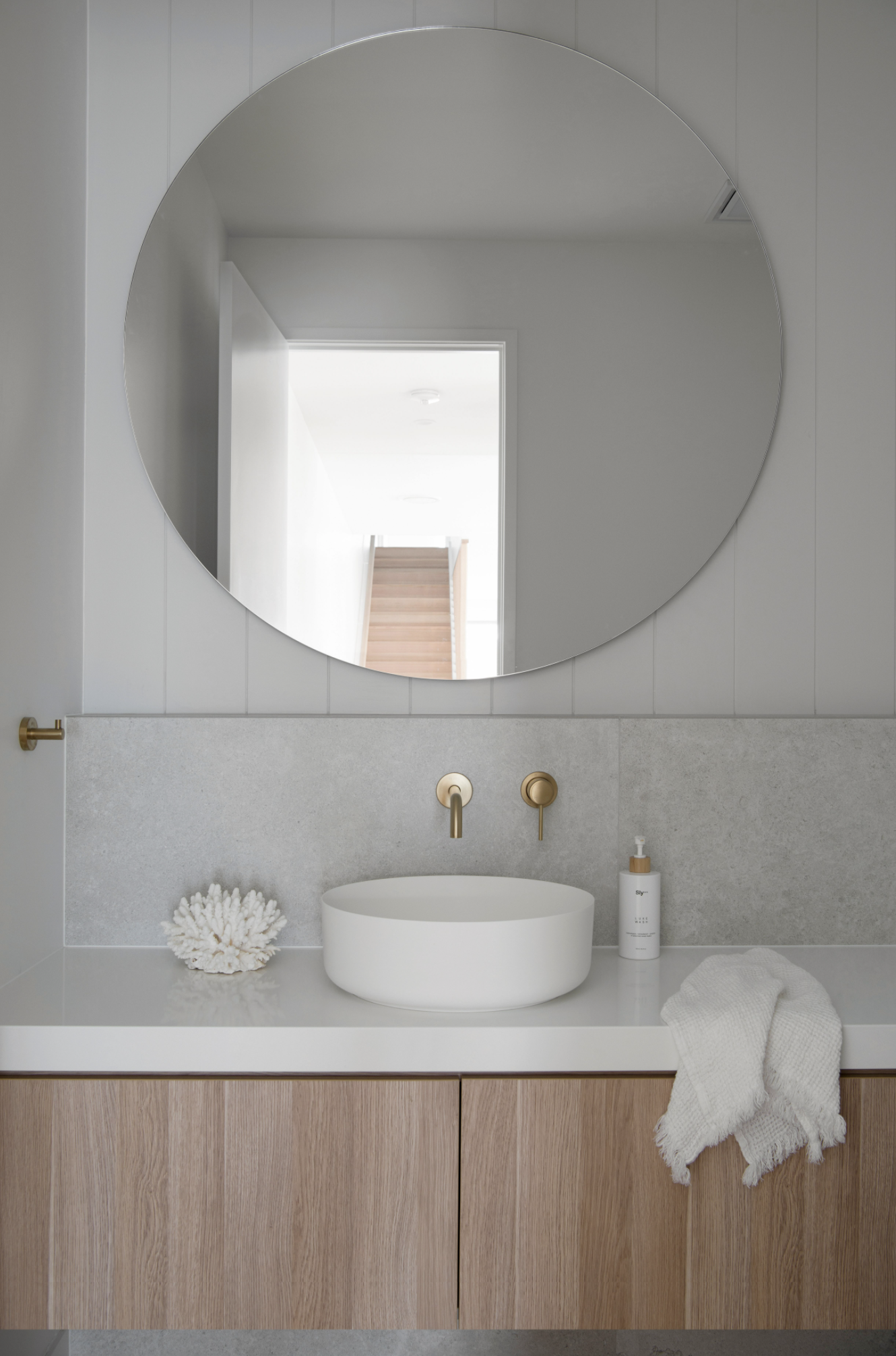 Round vanity mirror and small round sink basin in classic coastal Powder room project included in classic coastal home design bundle for home remodel