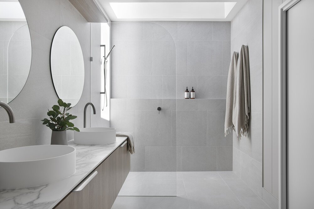 Round bathroom vanity mirror with grey shower niche wall in retreat house design bundle for home remodel