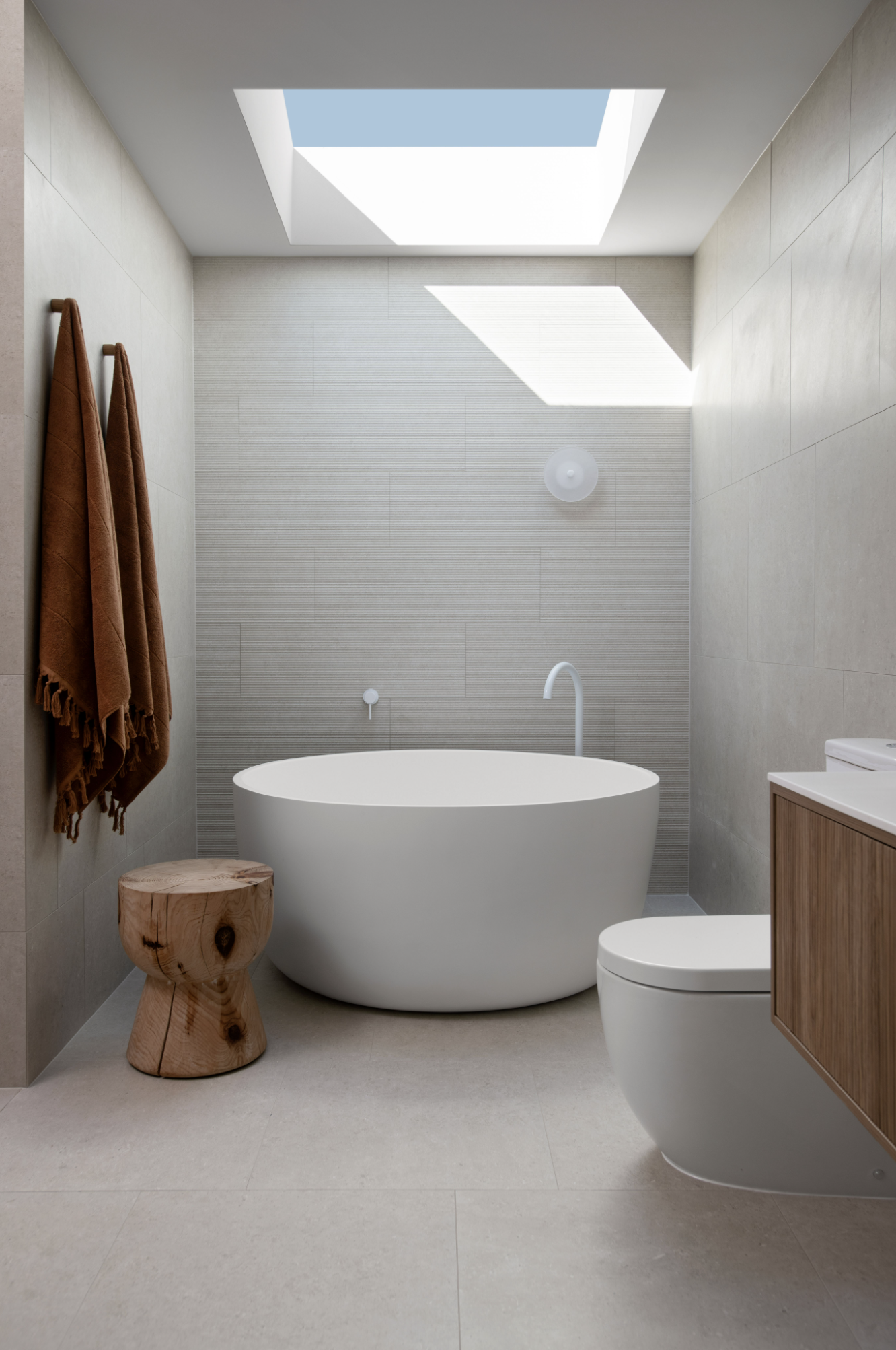 Round freestanding white bathtub with wooden stool on the side in Coral home design bundle for home remodel