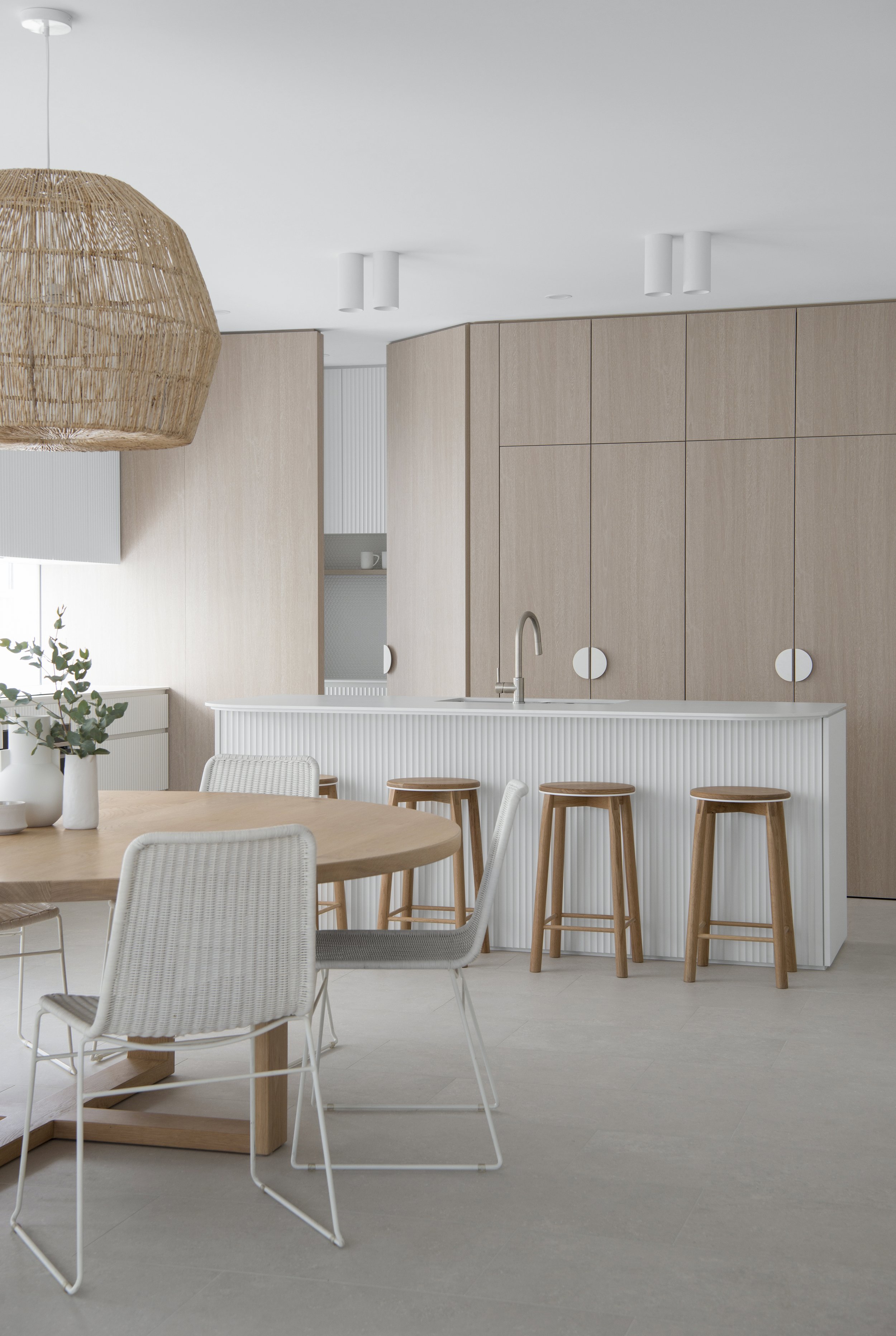 Wood stools and a white kitchen counter from contemporary coastal kitchen design project included in the kitchen design bundle.