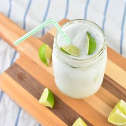 mason jar filled with fizzy mocktail with a straw and lime garnish