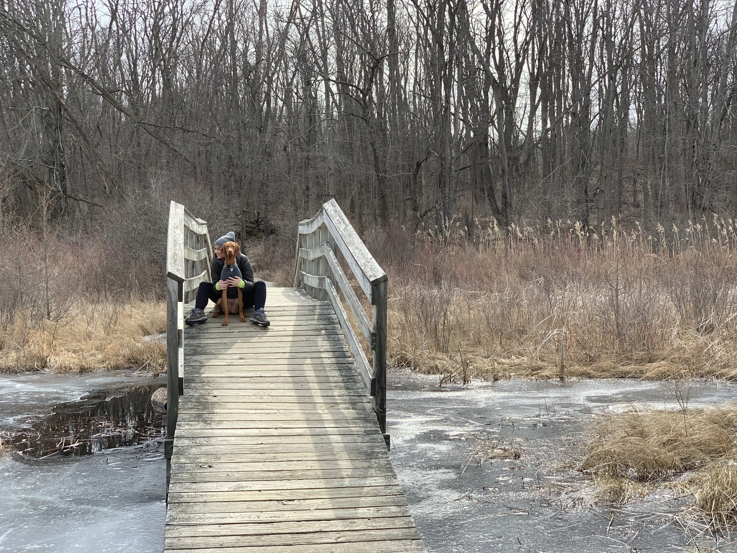 Recovery coach Samantha hugging her Vizsla on a bridge