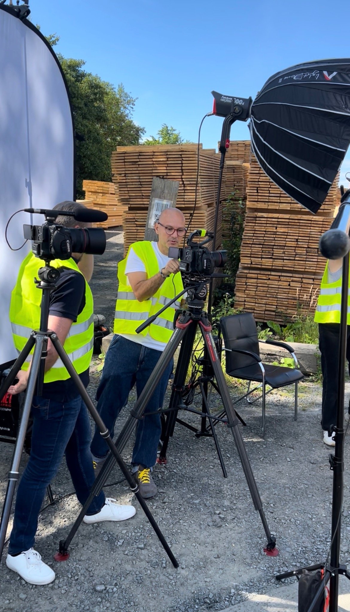 Sven Cichowicz und Filmteam mit Kameras, Mikrofonen und Lichttechnik bei einem Außendreh im Holzlager.