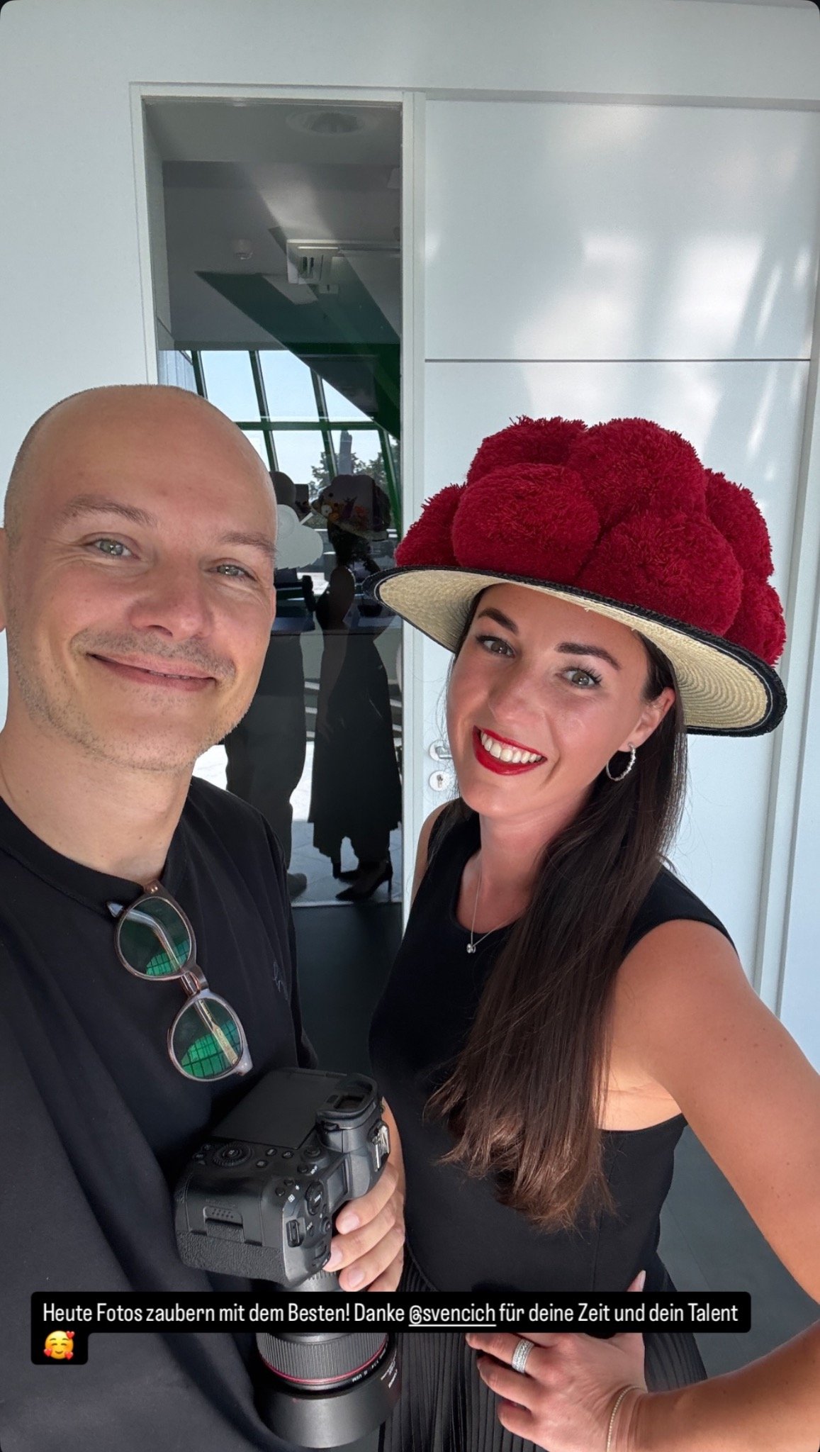 Sven Cichowicz mit einer Frau mit rotem Hut bei einem Fotoshooting.