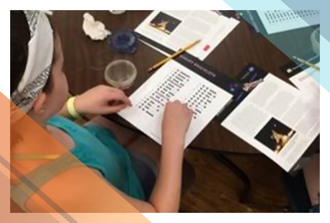 Girl Scouts examine coding handouts during the How to Talk to a Spacecraft workshop.