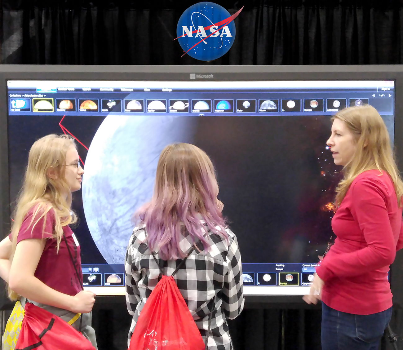 A subject expert demonstrates Jupiter's moon, Europa, in the World Wide Telescope application to visitors at the Science and Engineering Festival.