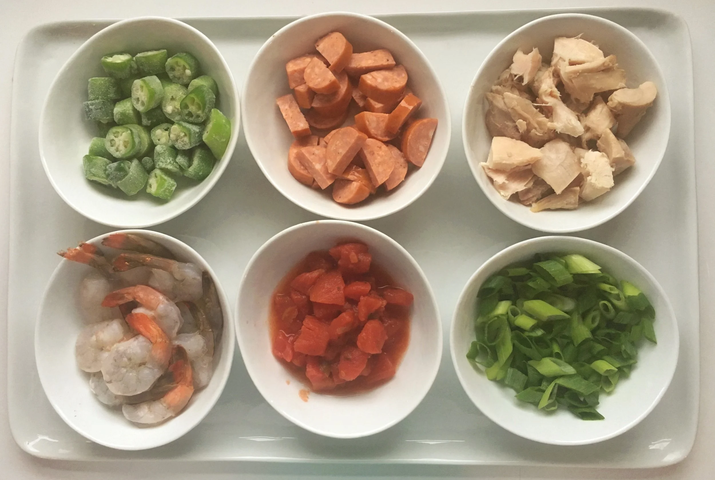 These are the players I have on my usual gumbo team. Clockwise from top left, okra, andouille, chicken, scallions, tomatoes, and shrimp. 