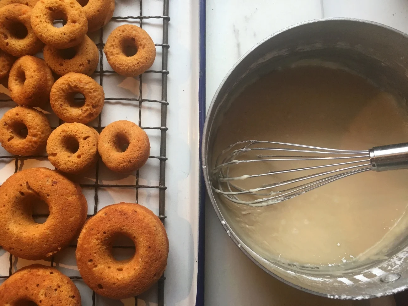 Dip the doughnuts, give 'em a little swirl and let the excess drain back into the pan. The glaze sticks a little better when it's warm. If it gets too thick, whisk in a little bit of milk.
