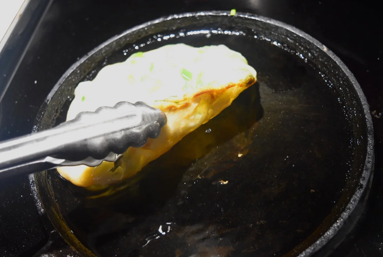 Once the edges look set and dry, you can take a peek to see if the first side is browned.